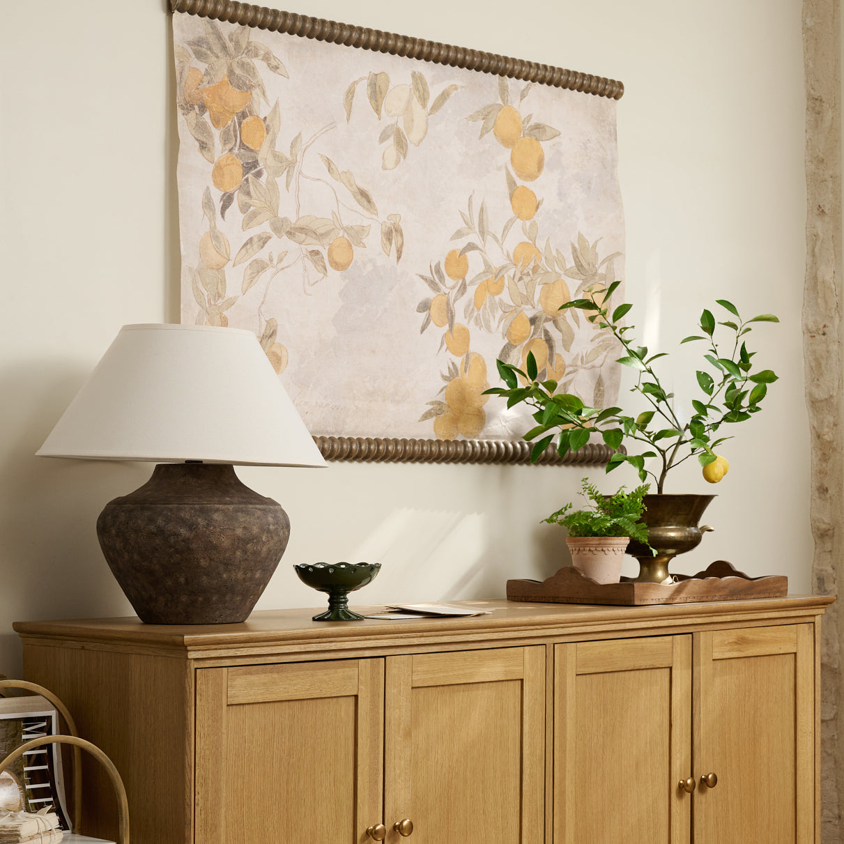 Vintage Arancia Tapestry in a room above sideboard with rustic lamp and decorative vases