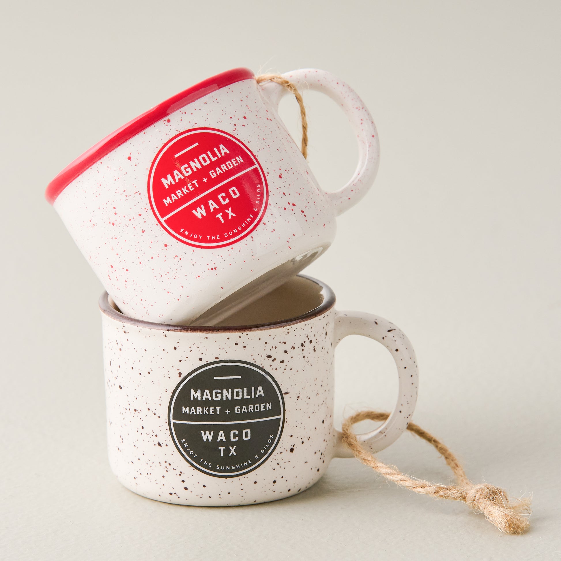 Red Magnolia Campfire Mug Ornament stacked on top of another campfire mug ornament in black