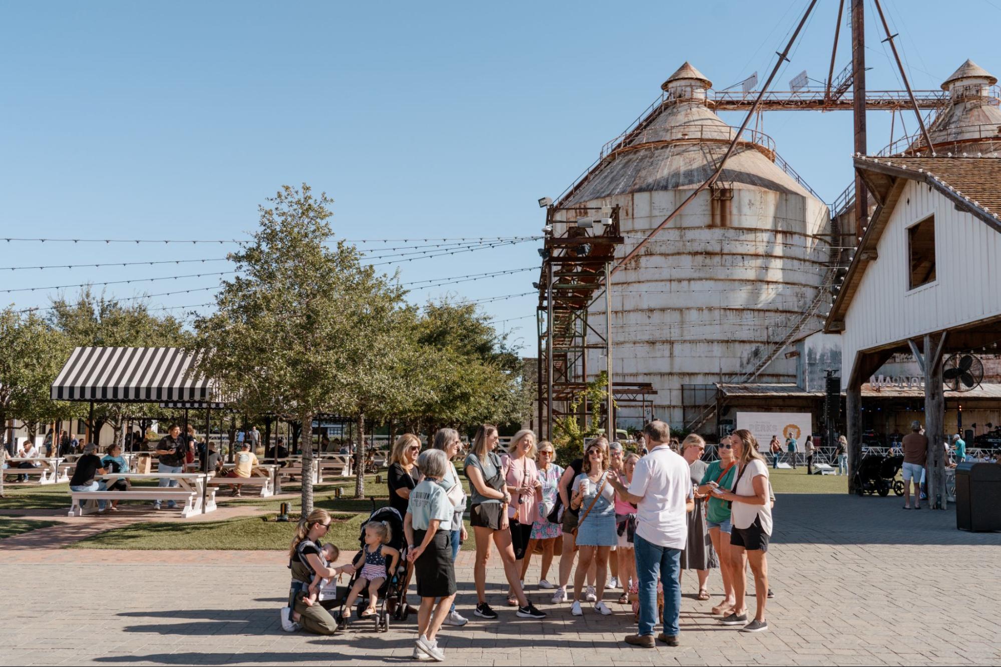 Group of people listening to tour guide next to Magnolia Silos