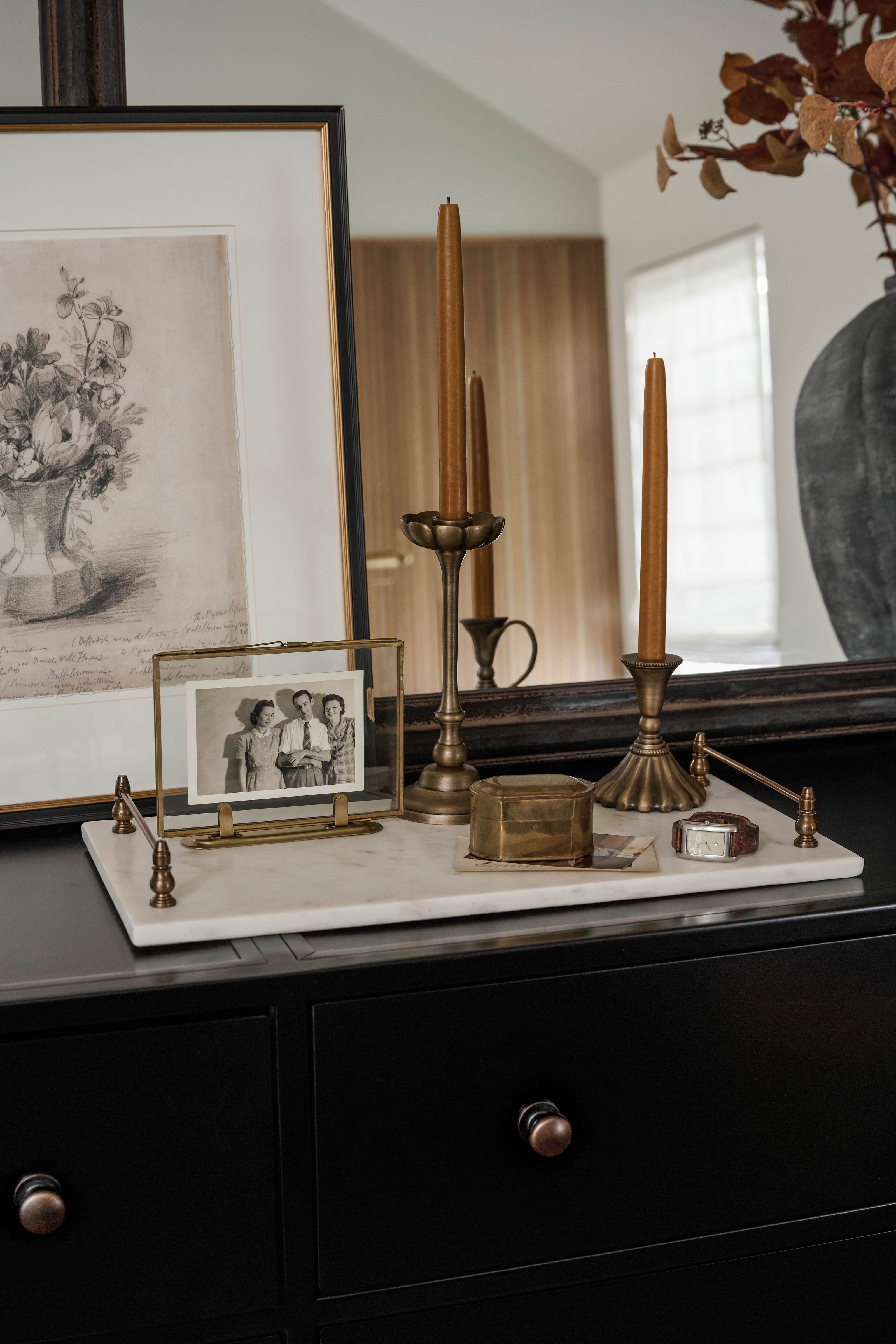 A white marble tray on a black dresser. 