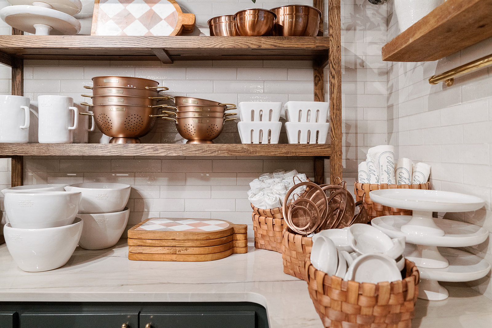 Kitchen pieces—like strainers, bowls, boards, and more—sit on shelves in Magnolia Market.