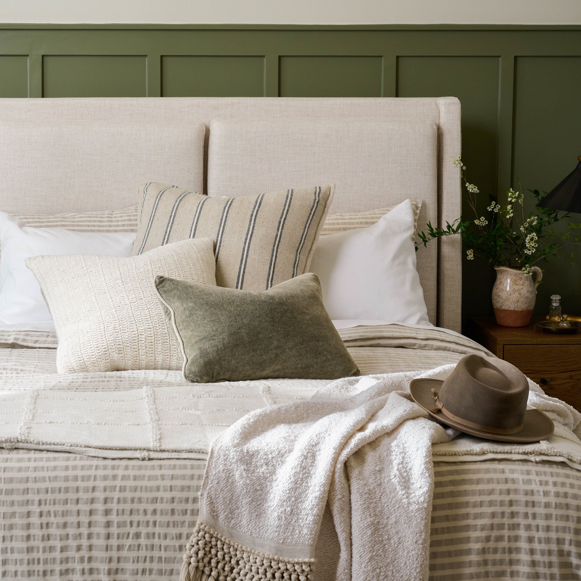 Angora Tassel Throw on the foot of a bed with a hat on top