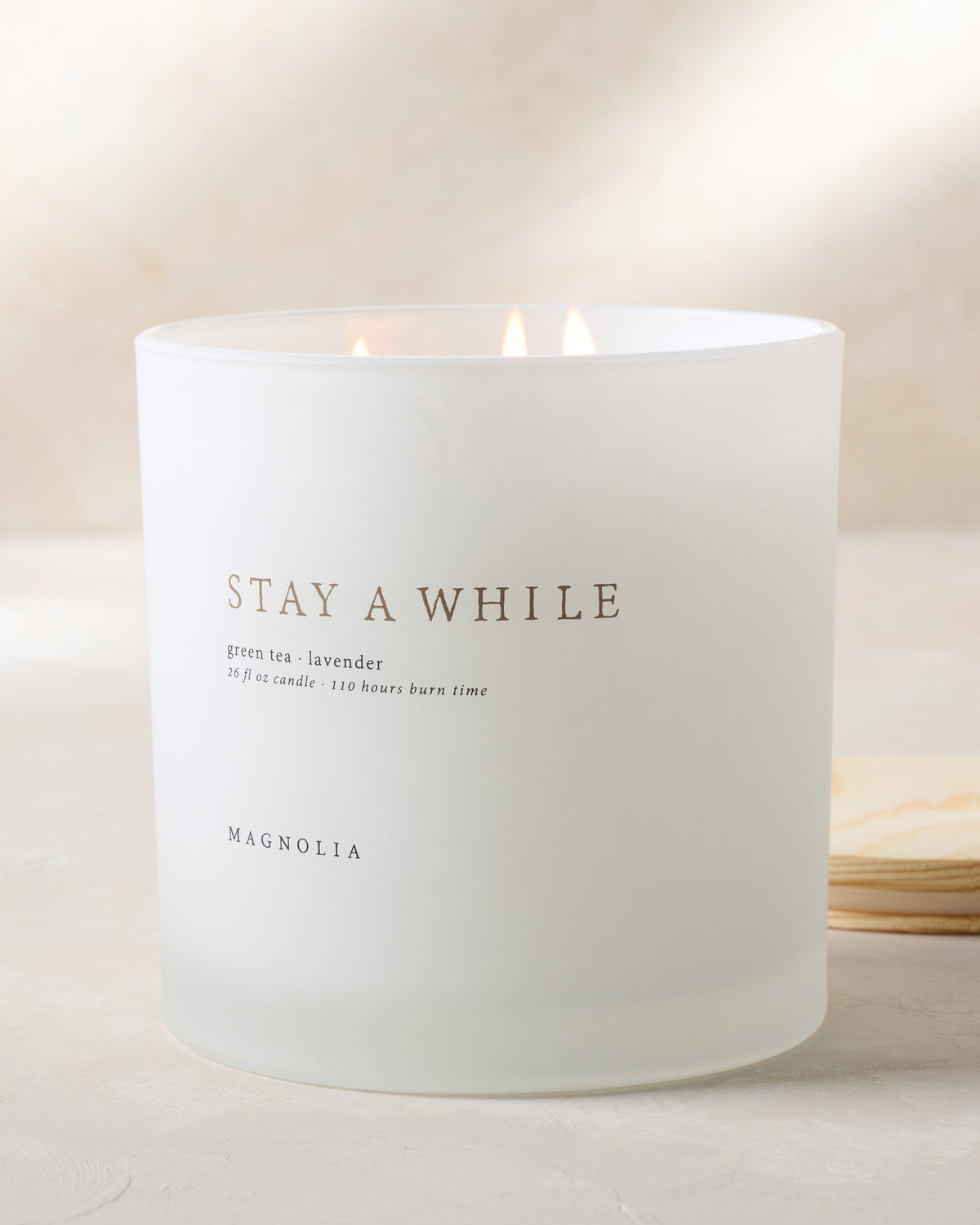 magnolia stay a while candle with wood lid notes scents of green tea and lavender