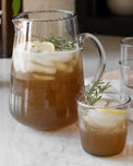 Elizabeth bottle cut pitcher and elizabeth bottle cut tumbler containing lemon and rosemary tea
