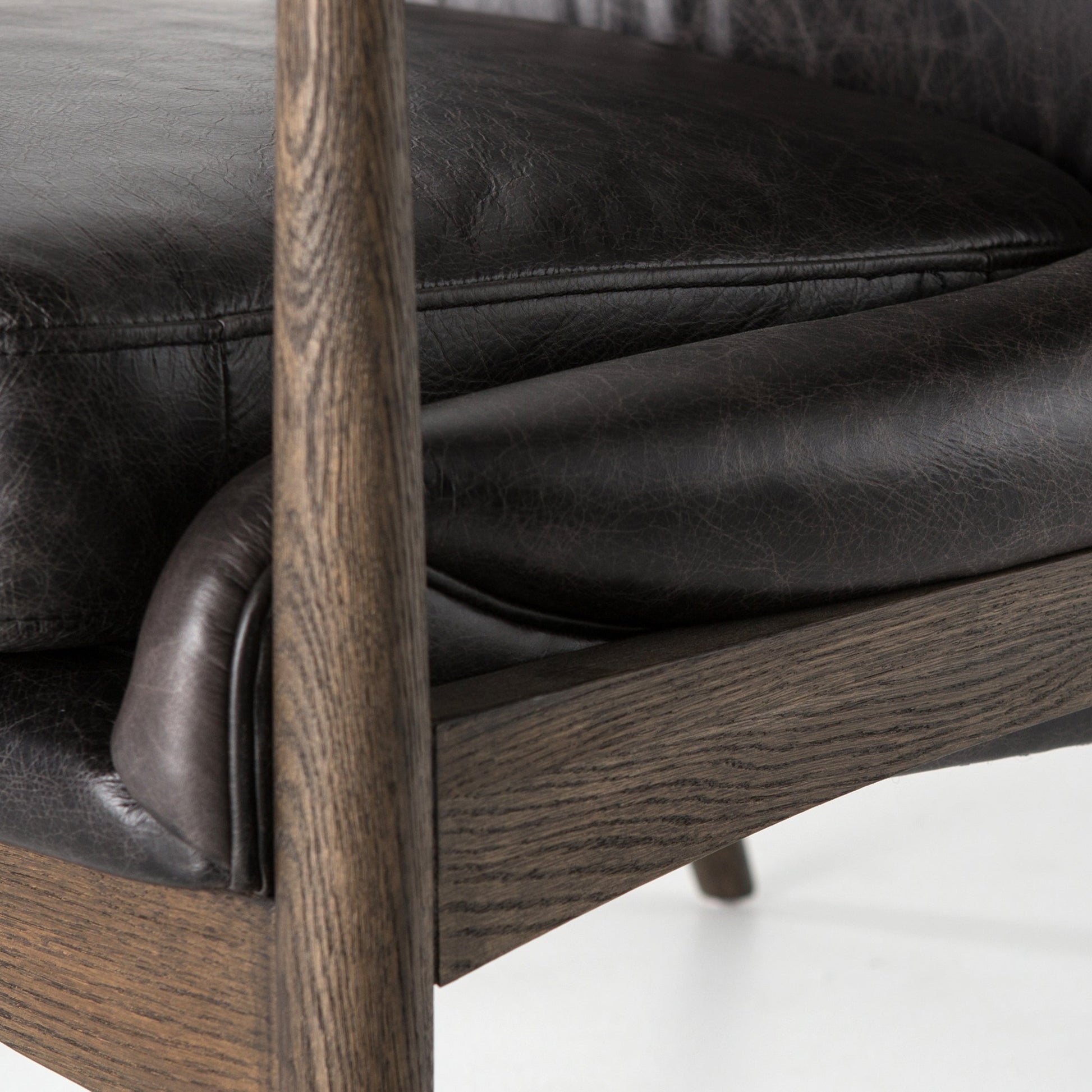 distressed black leather mid century modern arm chair with wooden arms and legs