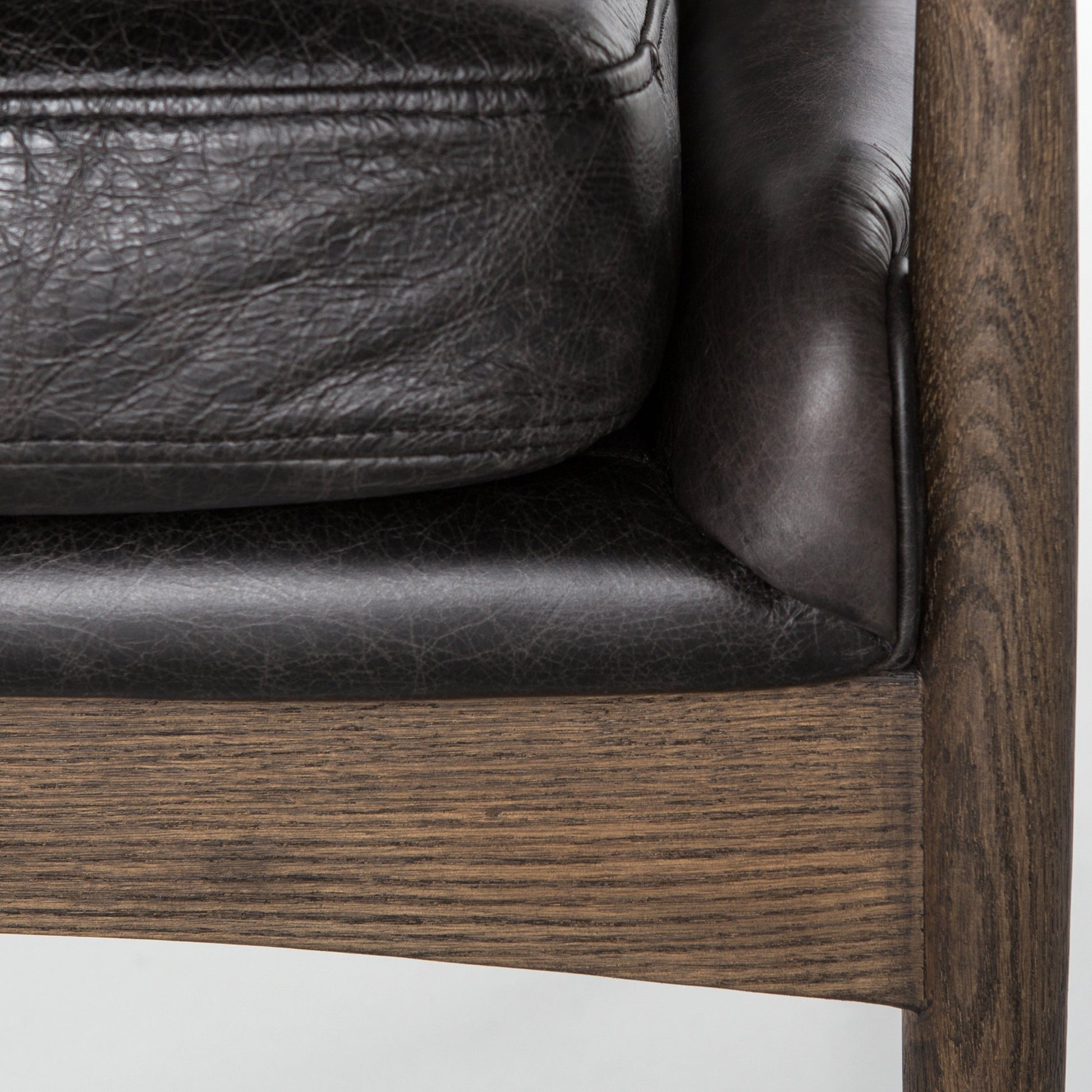 distressed black leather mid century modern arm chair with wooden arms and legs