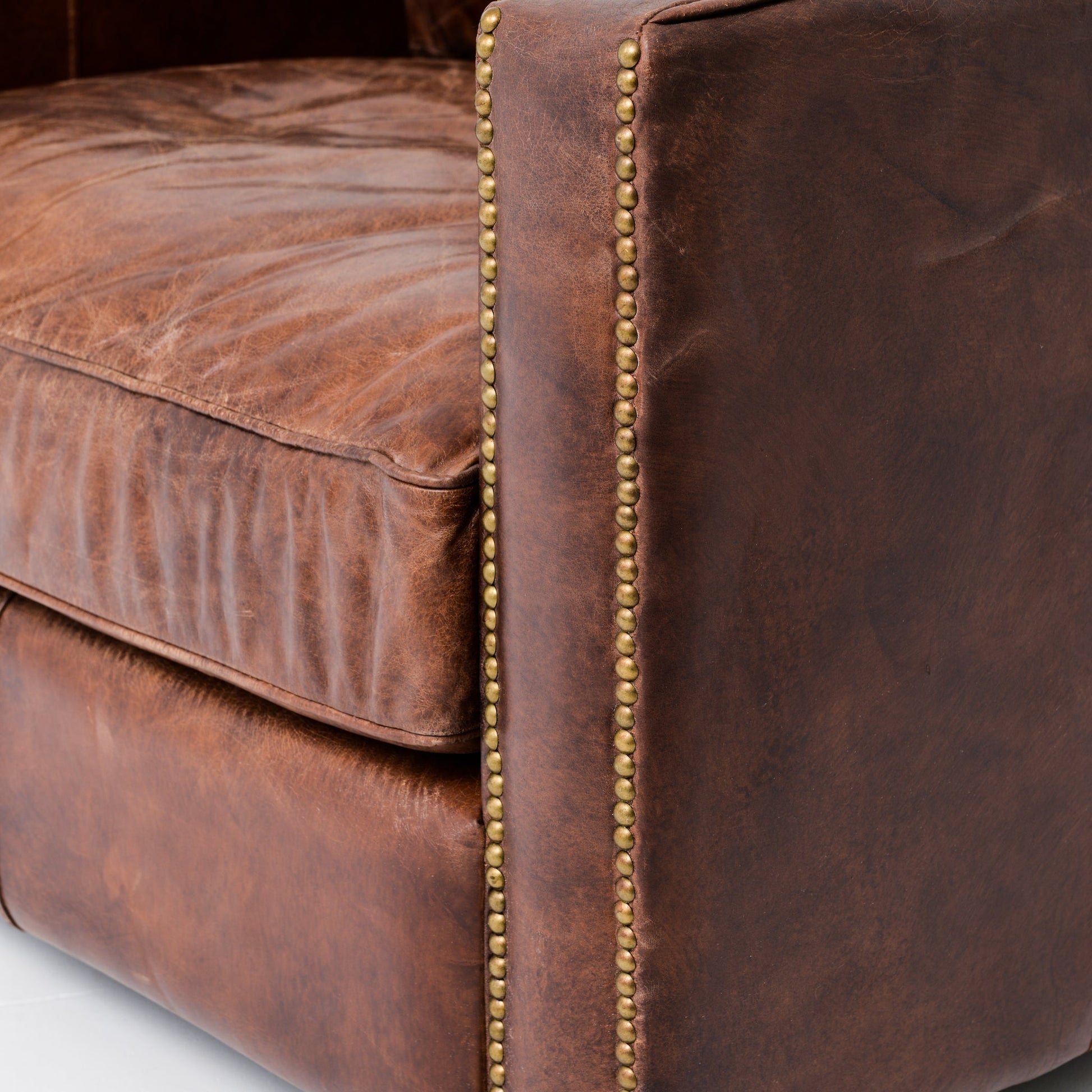 medium brown leather arm chair with nailhead arms