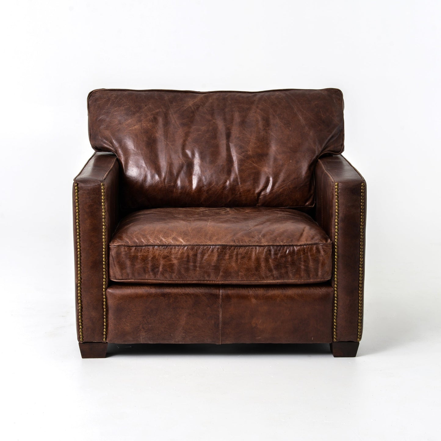 medium brown leather arm chair with nailhead arms