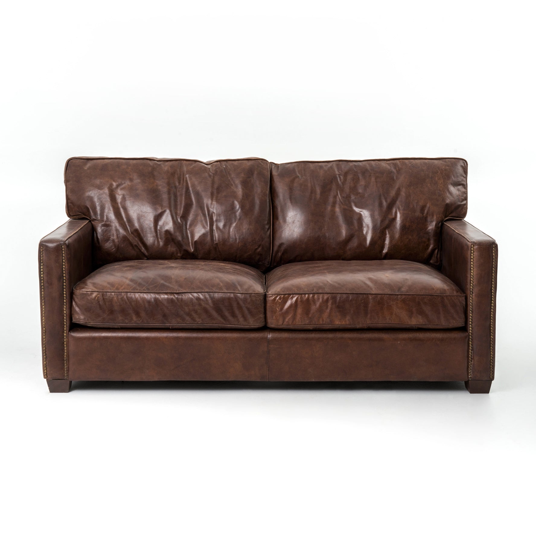medium brown leather sofa with nailhead arms