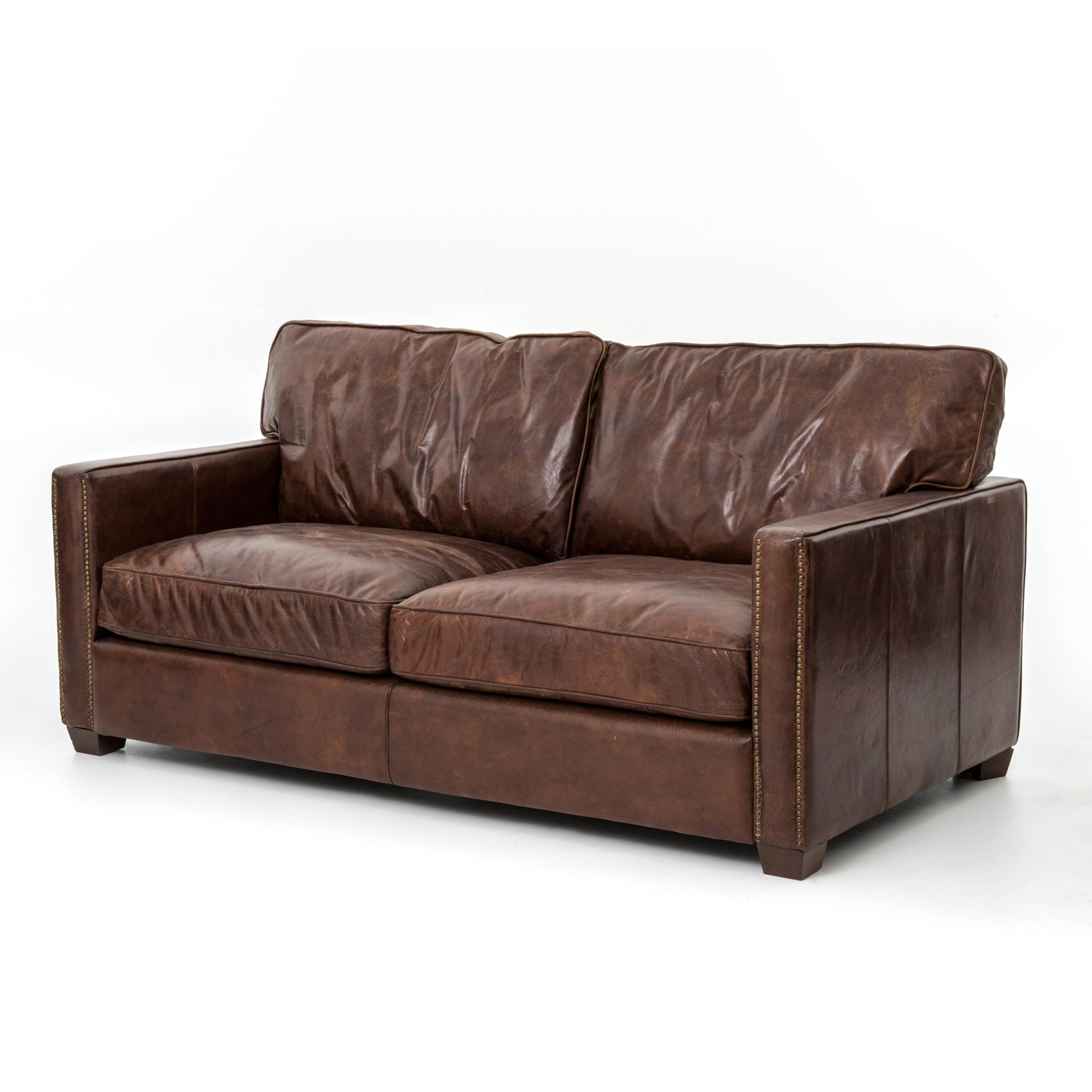 medium brown leather sofa with nailhead arms