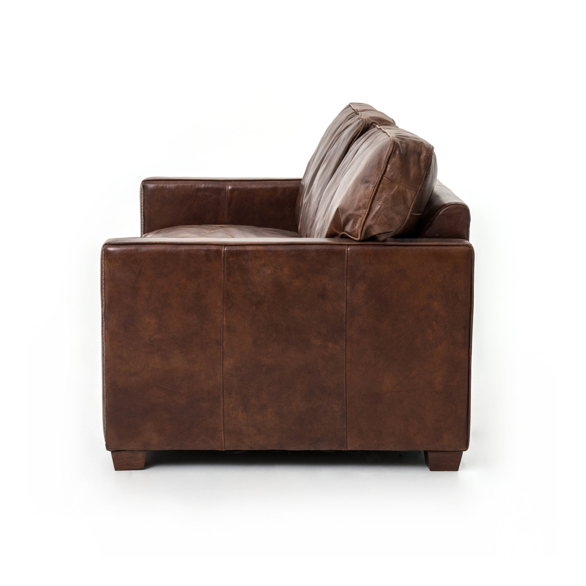 medium brown leather sofa with nailhead arms