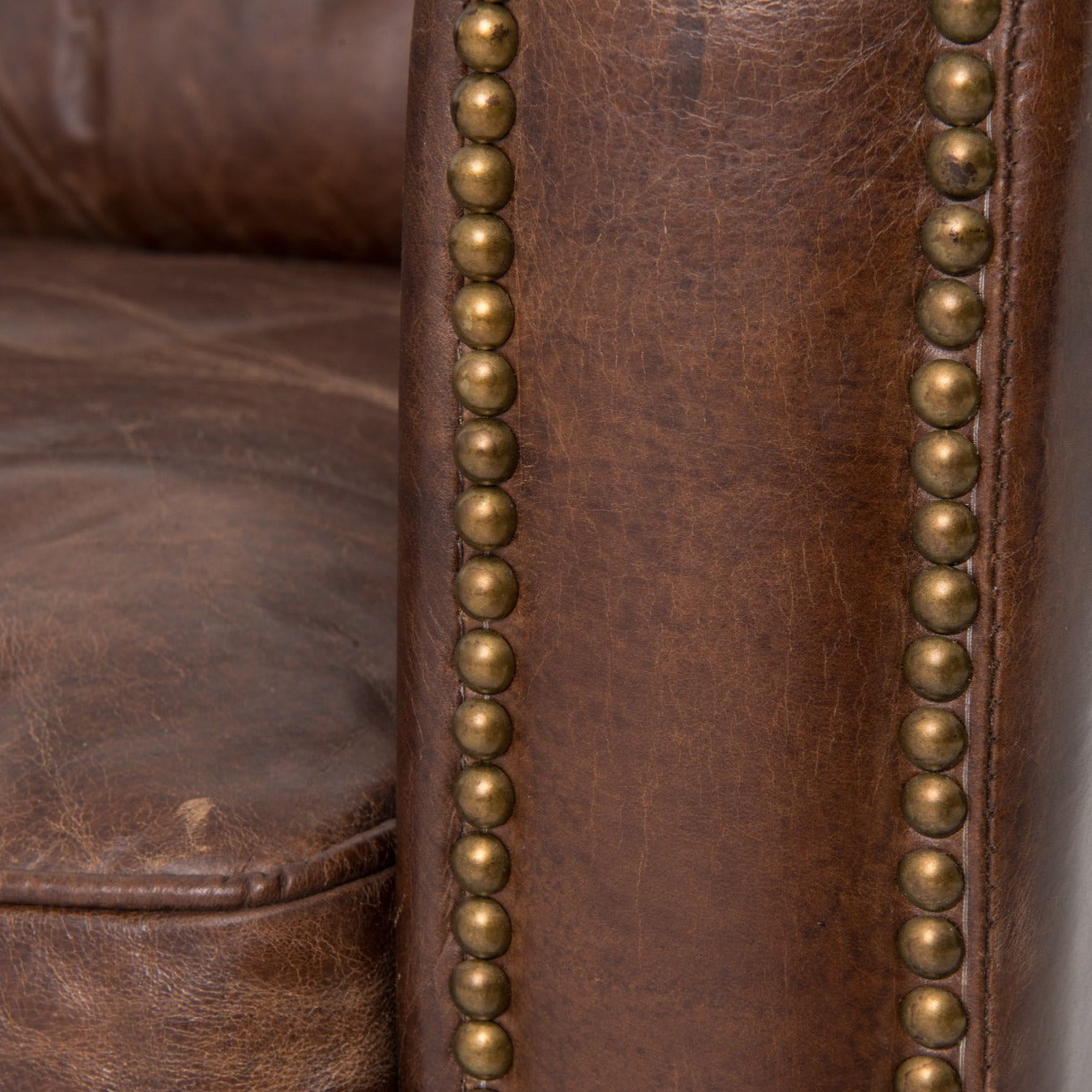 medium brown leather sofa with nailhead arms