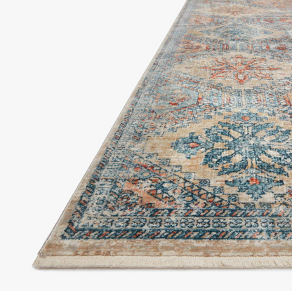 blue, orange, and tan diamond patterned rug with floral detail