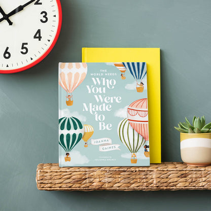 A children's book titled "The world needs who you were made to be" by Joanna Gaines