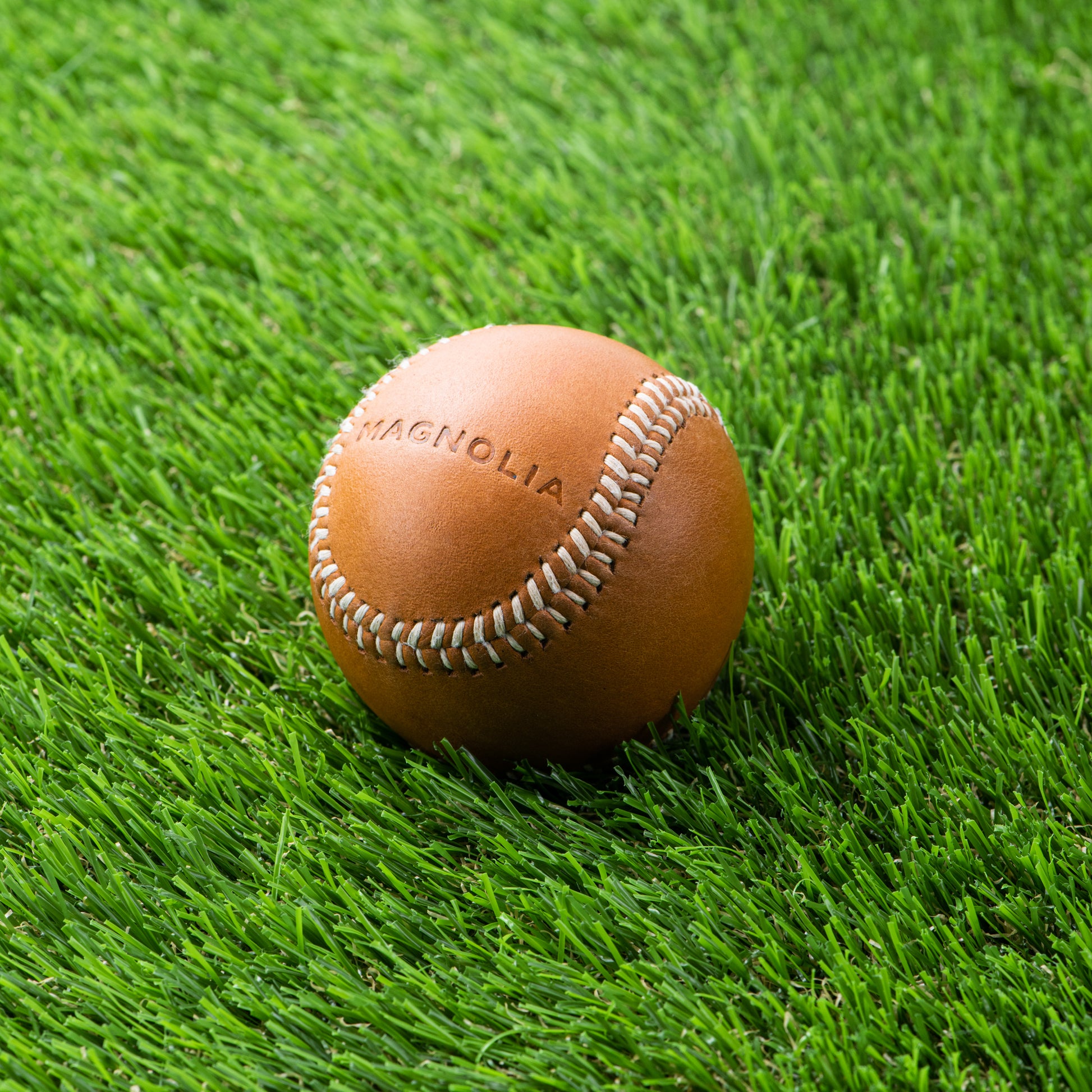 tan leather baseball with silos baseball logo and magnolia logo on the opposite side