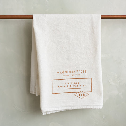 white tea towel with magnolia press logo in copper