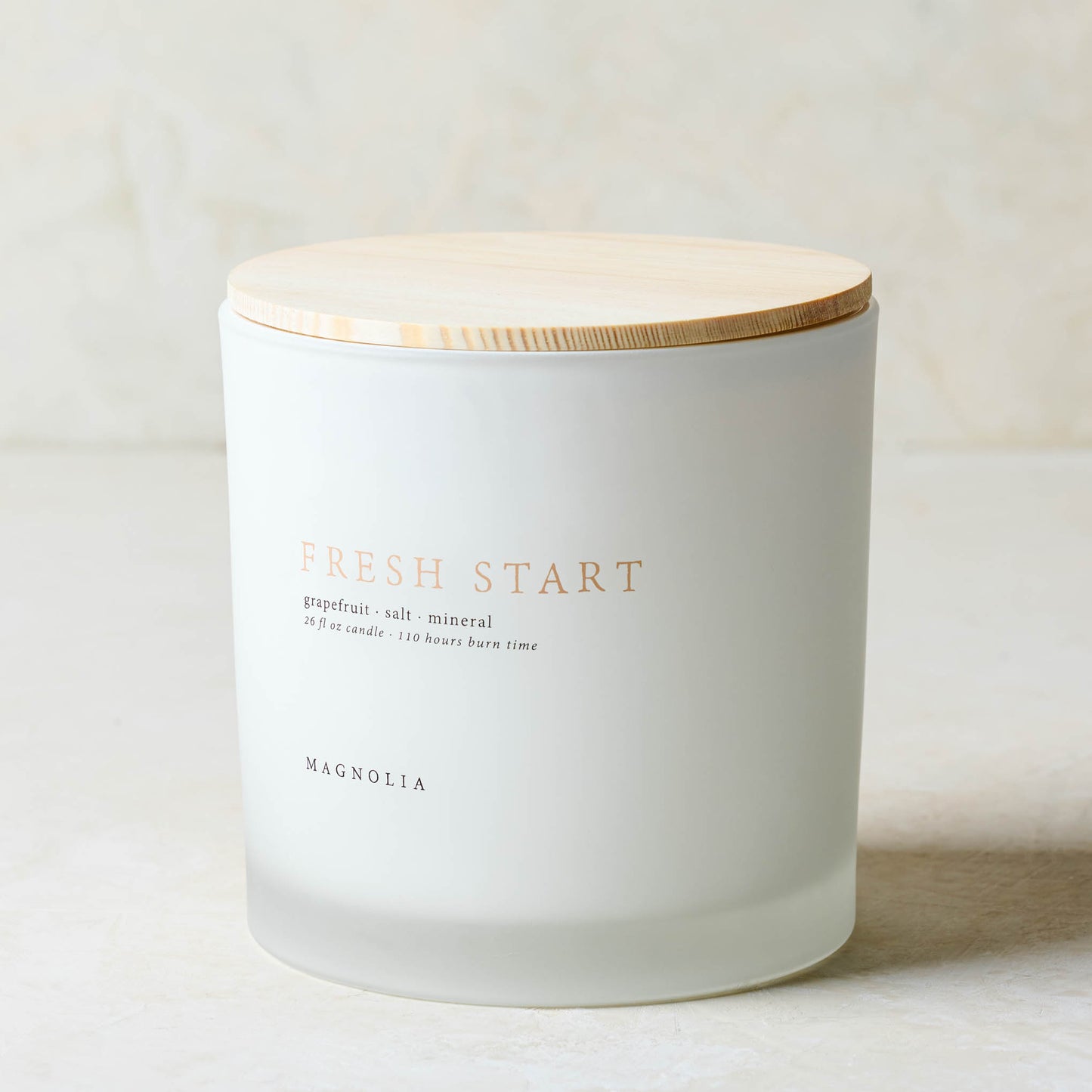 magnolia fresh start candle with wood lid notes scents of grapefruit salt and mineral