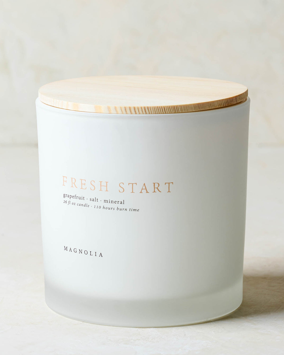 magnolia fresh start candle with wood lid notes scents of grapefruit salt and mineral