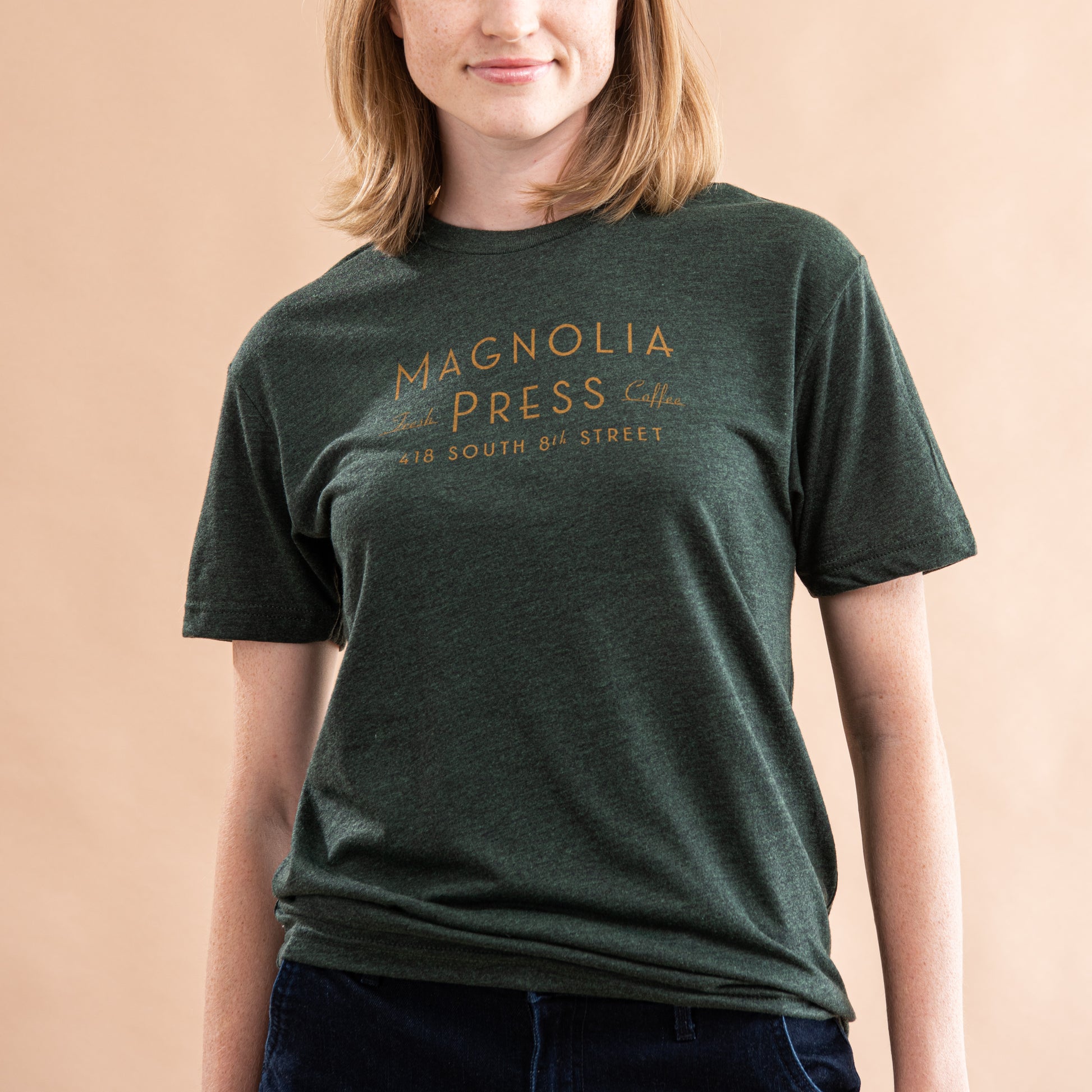 emerald green t-shirt with magnolia press coffee logo in gold across chest