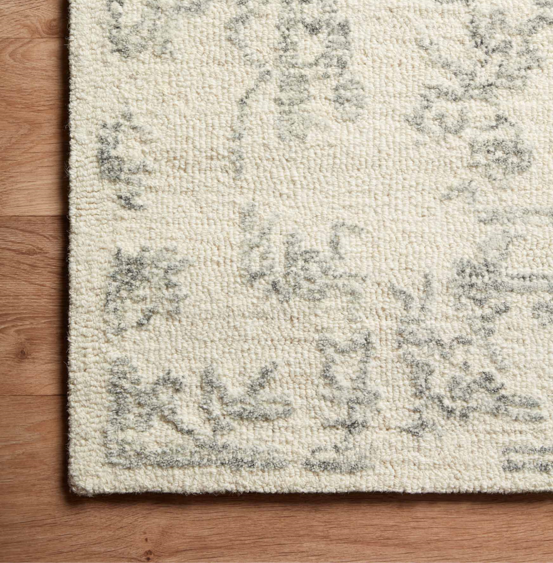 cream and grey distressed area rug with traditional detail