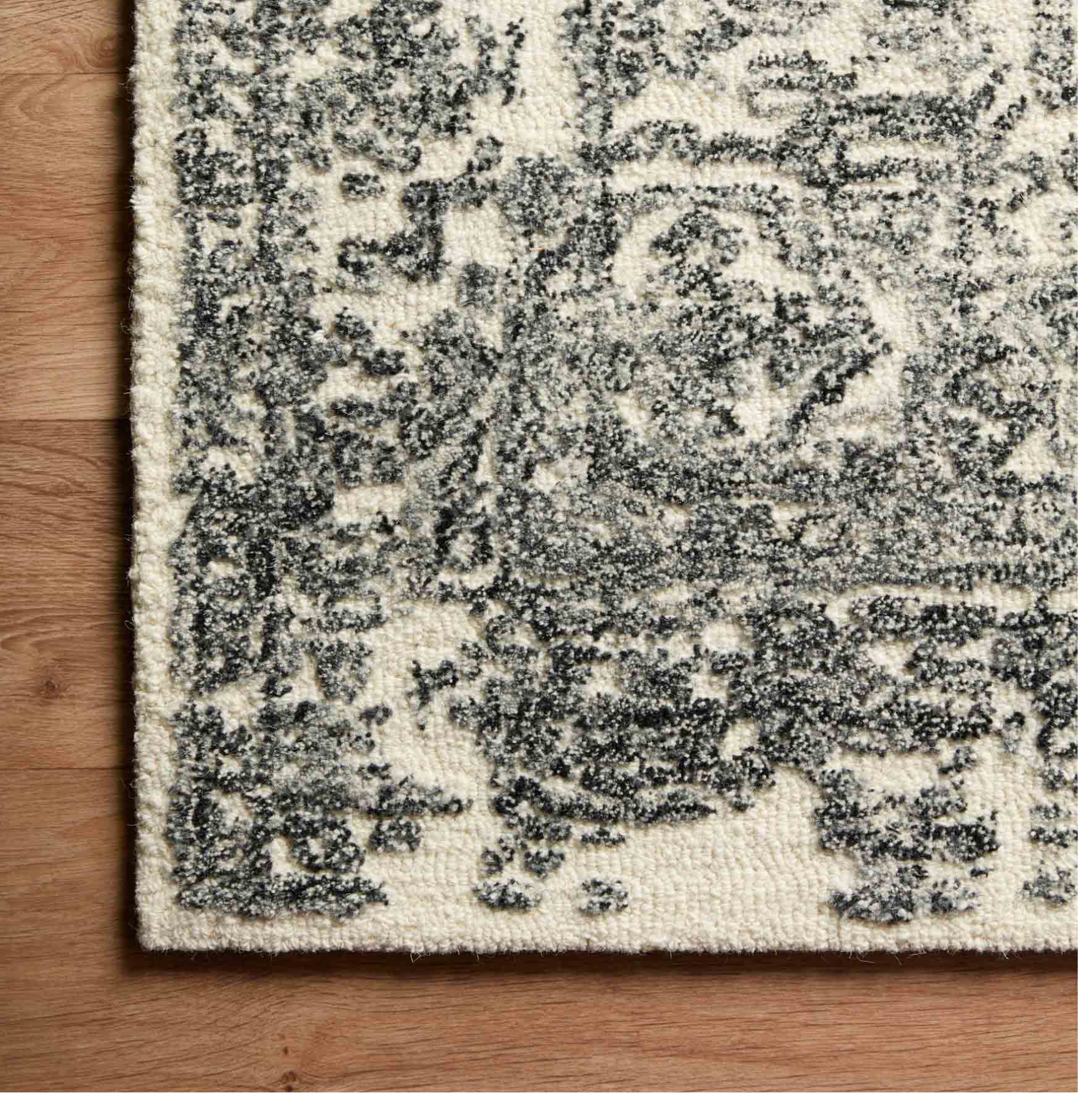 cream area rug with black traditional patterns and detail