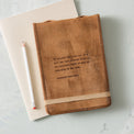 leather journal with excerpt from magnolia manifesto embossed on the cover