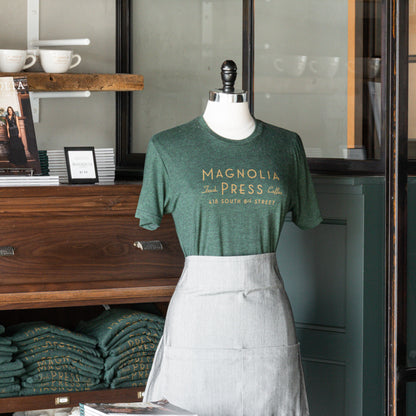 emerald green t-shirt with magnolia press coffee logo in gold across chest