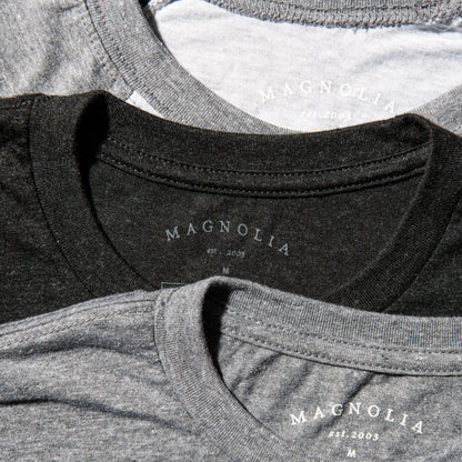 black heathered t-shirt with white magnolia silos seal logo