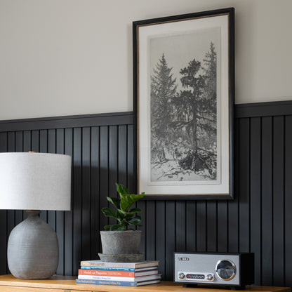 Framed wall art called Tall Trees II hanging on wall above wood dresser