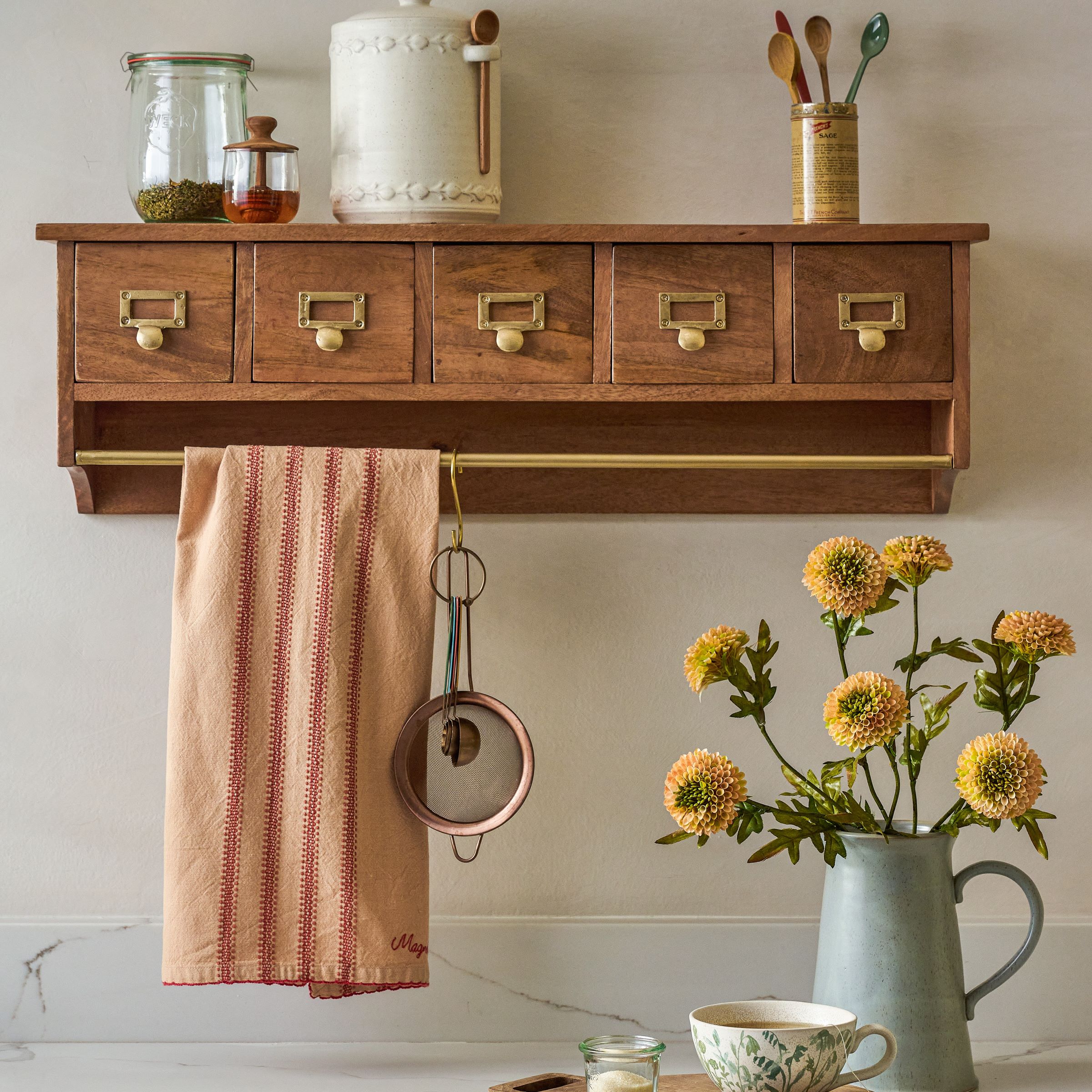 wooden wall shelf with five drawers and a brass towel rod