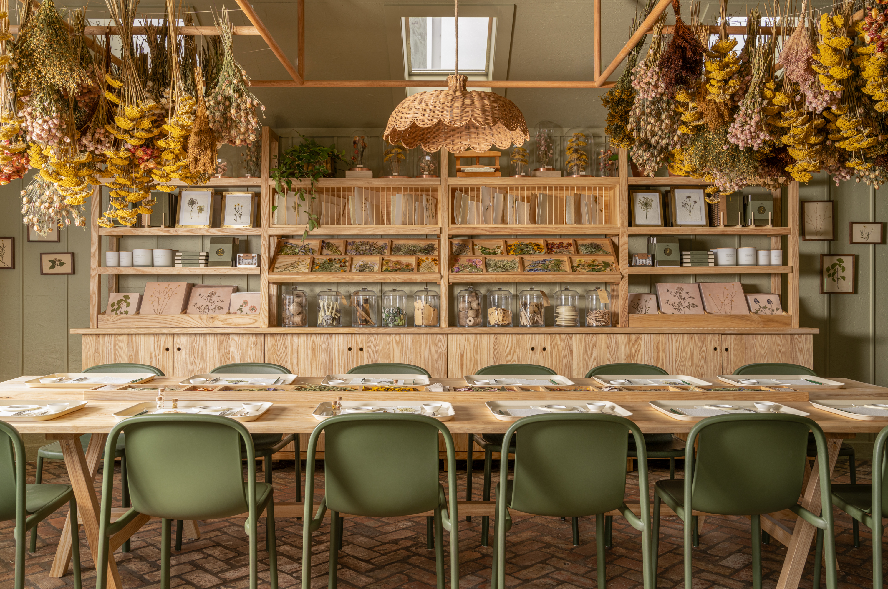 The Herbarium at the Magnolia Silos—filled with green chairs, wooden tables and shelves, dried florals, and more.
