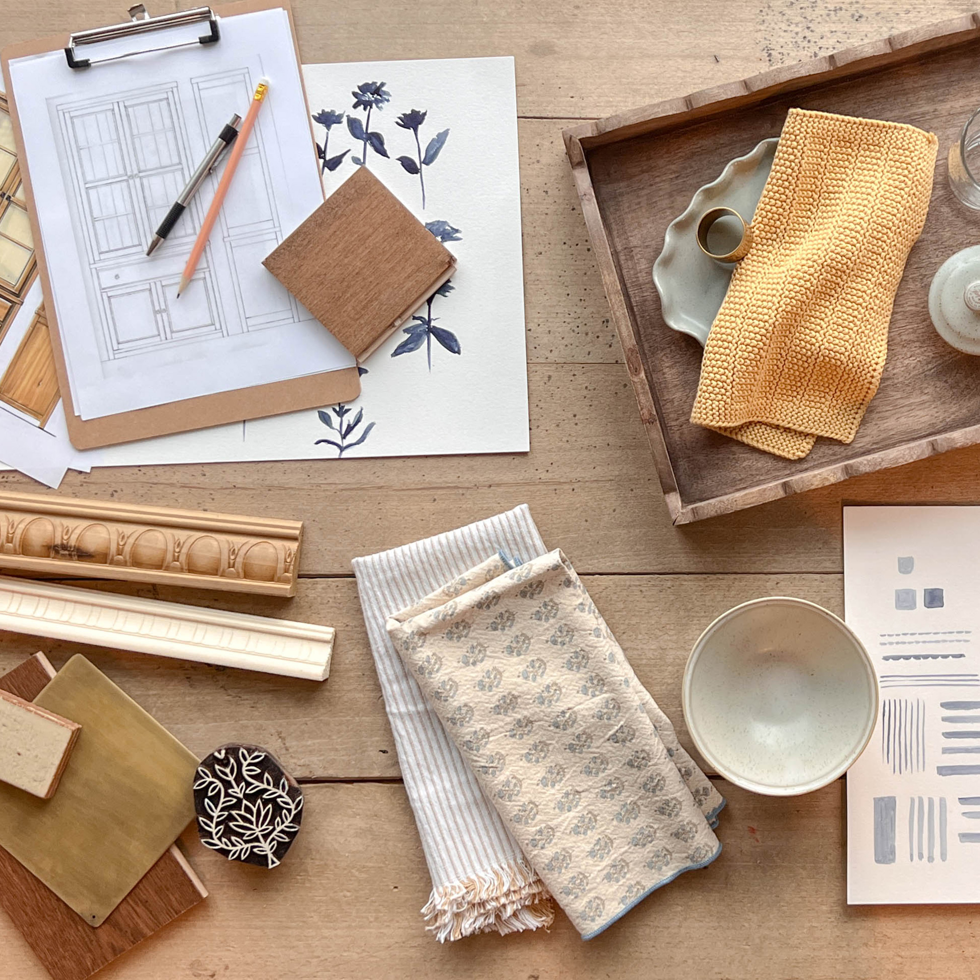 Magnolia-exclusive product sketches, samples, and details sitting on a wooden floor.