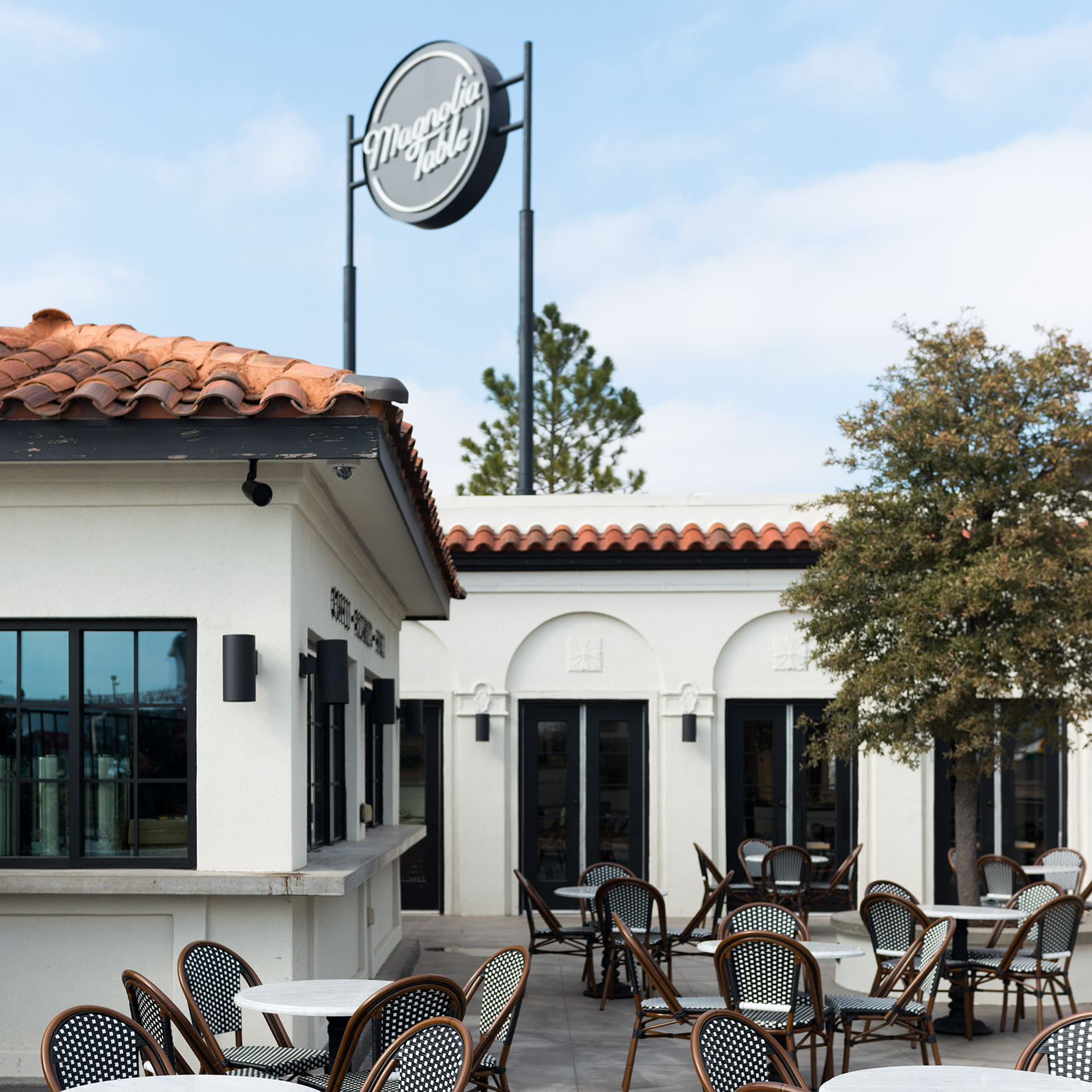 Outdoor seating area at magnolia table with tables and chairs