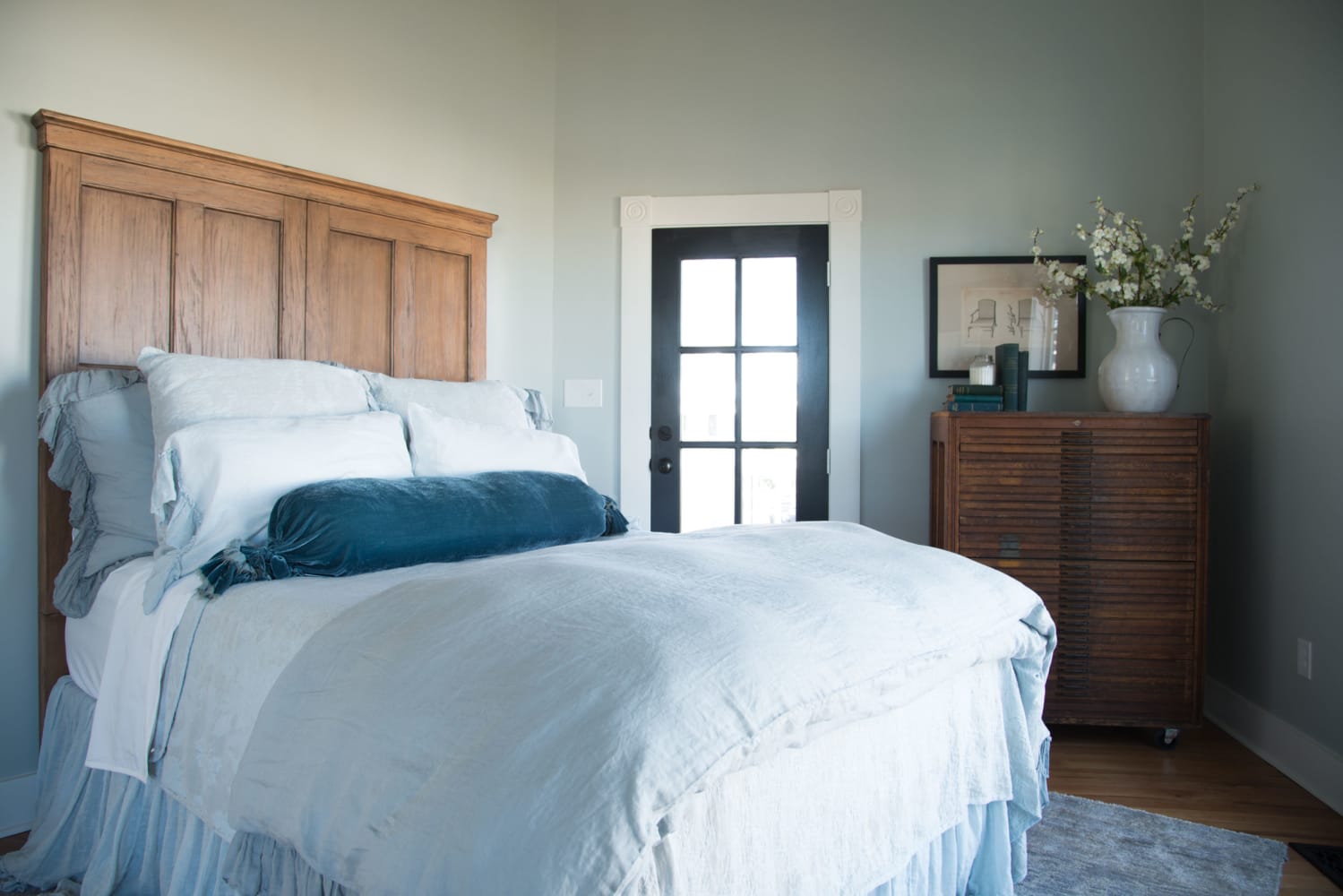 Light blue grey paint color on walls of bedroom with country, relaxed farmhouse style at The Magnolia House in McGregor, TX. Design by Joanna Gaines.