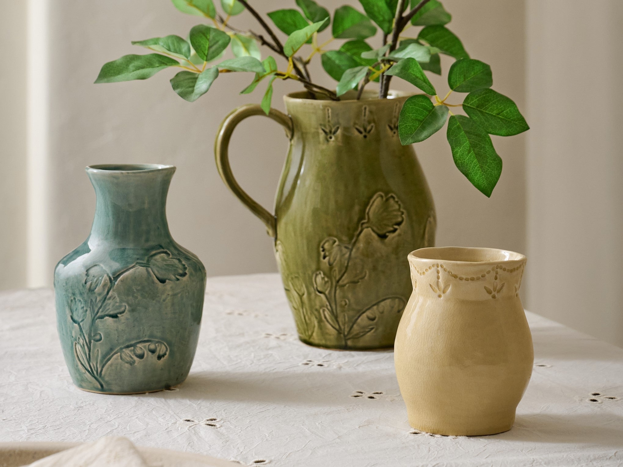 three floral glozed vases in blue green and yellow