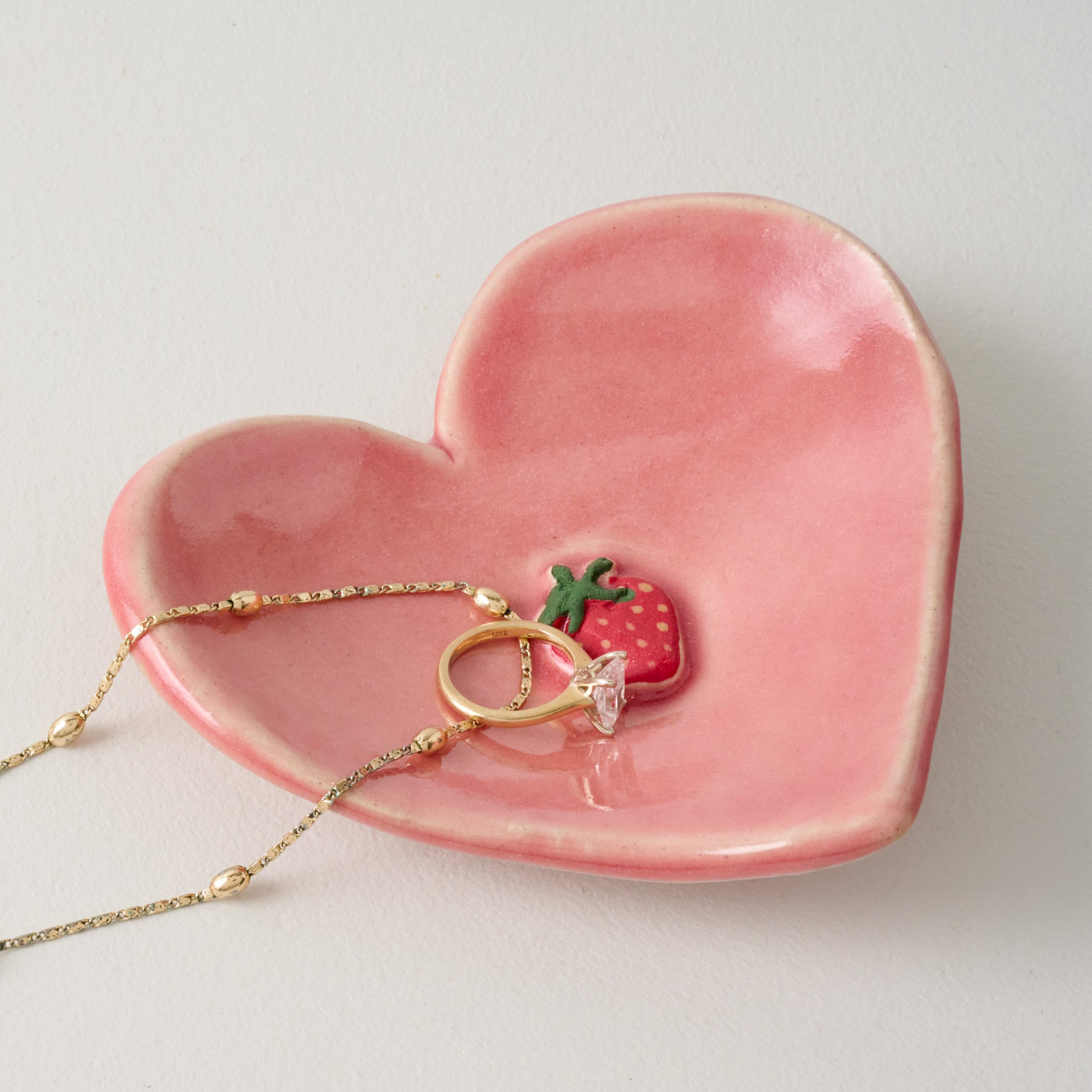 Black Oak Artisan Strawberry Heart Trinket Dish shown with ring and necklace $22.00