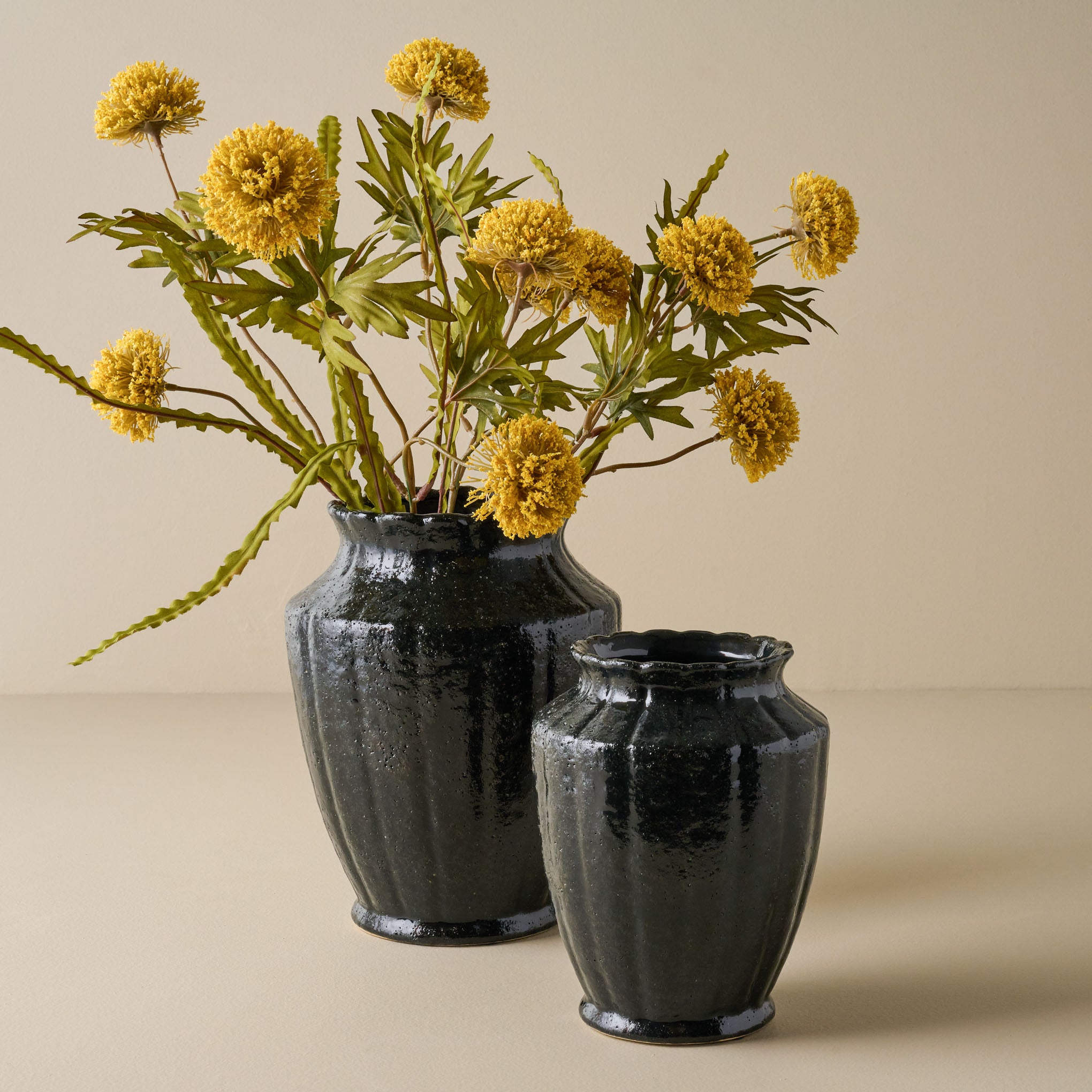 Small and Large Glazed Black Scalloped Vase shown with flowers On sale with items ranging from $9.99 to $14.99, discounted from $24.00 to $34.00