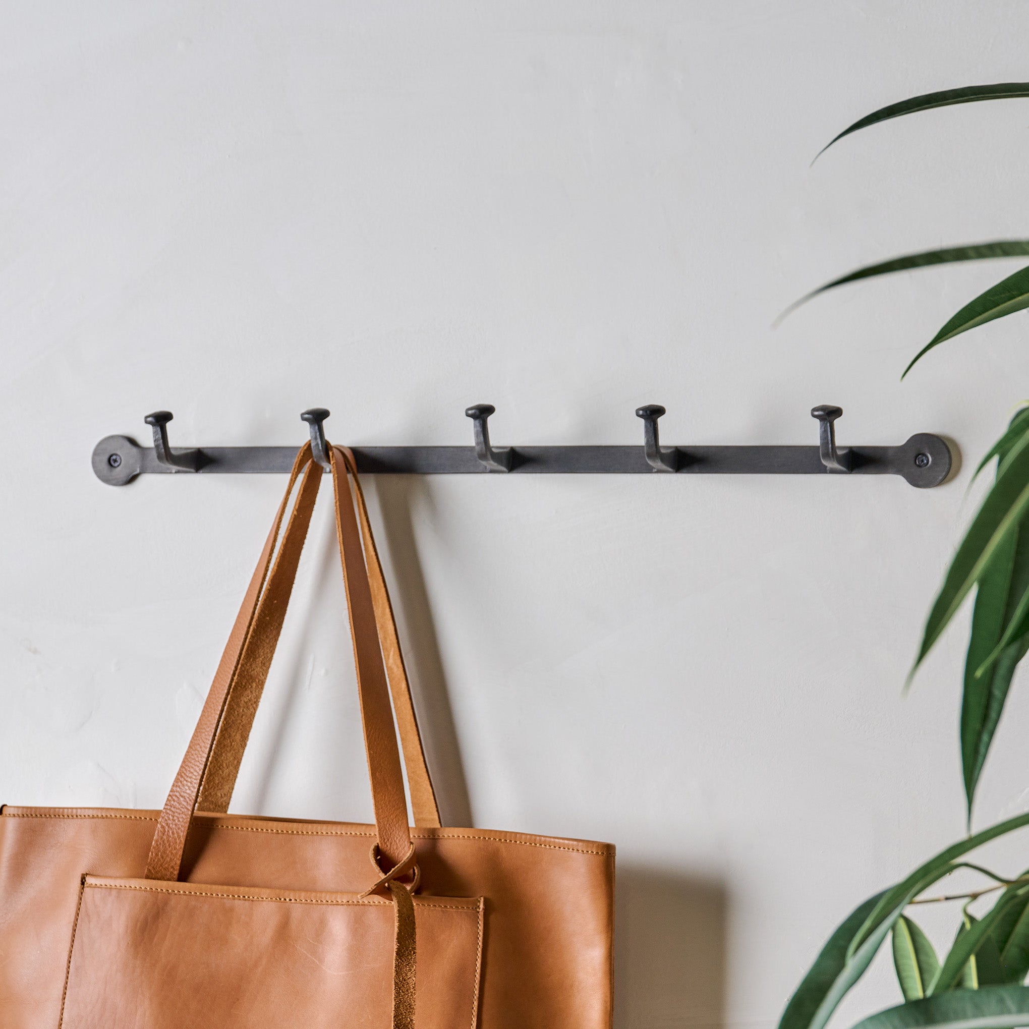 Large Hammered Aged Iron Wall Hooks shown with purse hanging Items range from $24.00 to $38.00