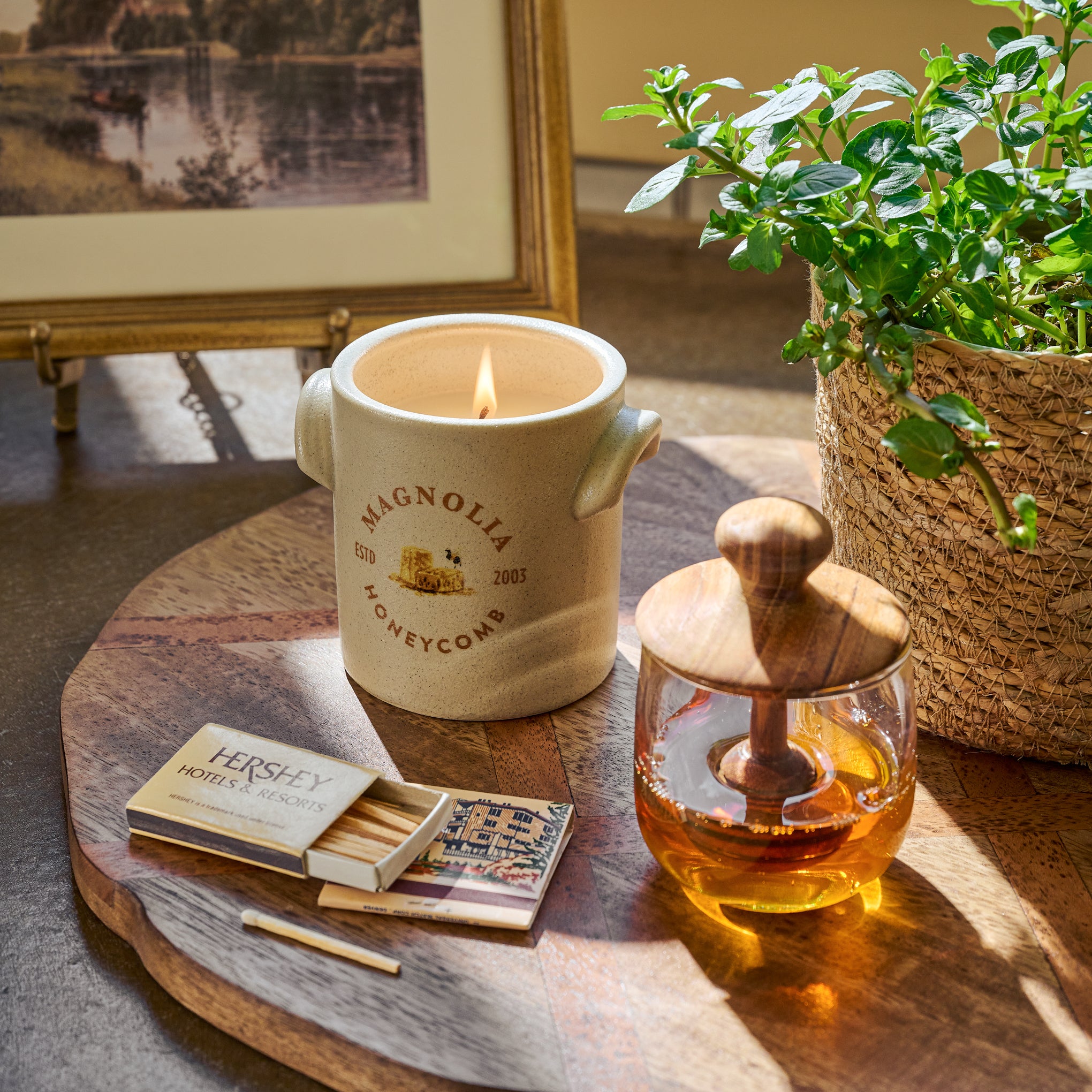 Magnolia Honeycomb Candle next to matches and a honey pot $24.00