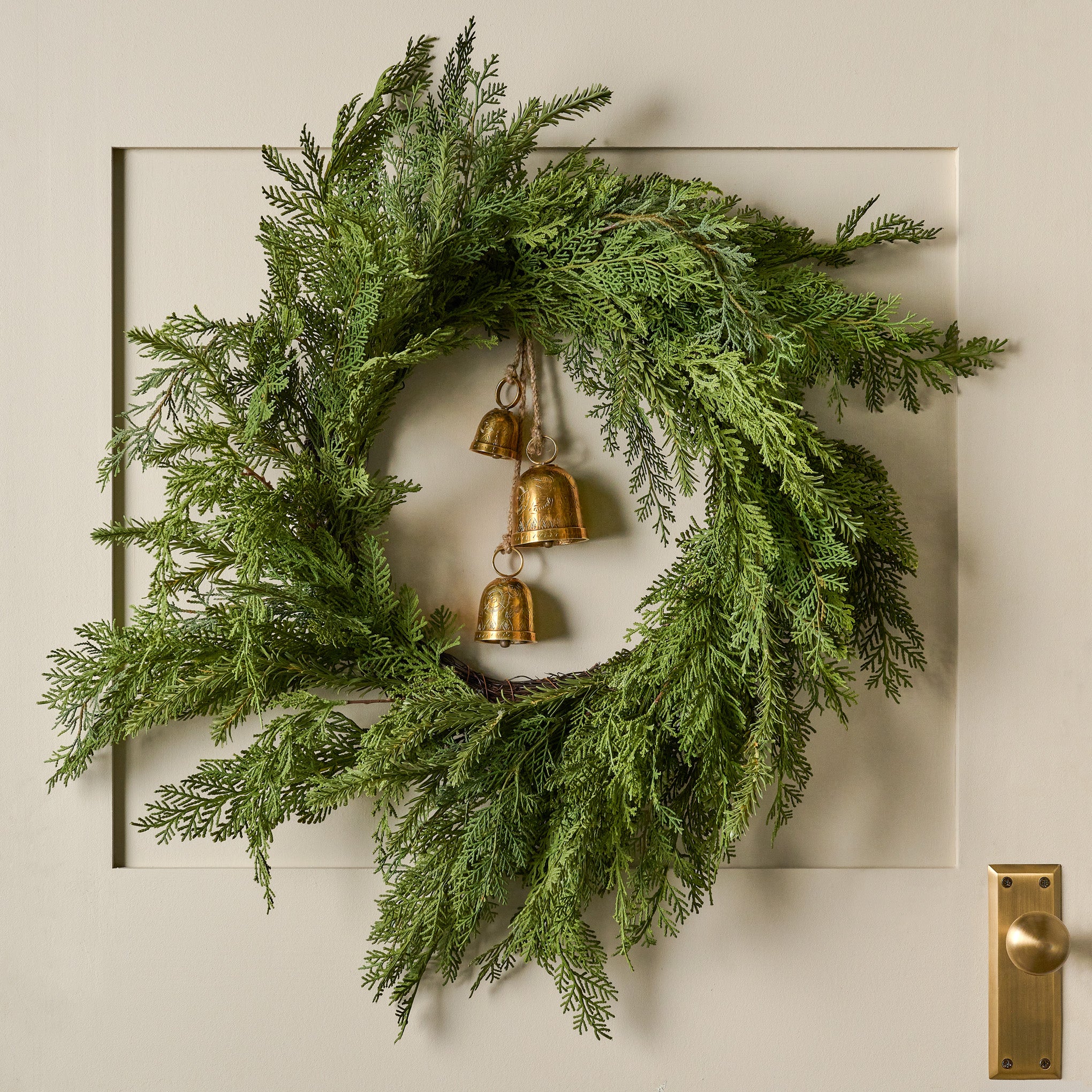 Real Touch Cedar Mix Wreath shown hung on door with bells On sale for $54.99, discounted from $98.00