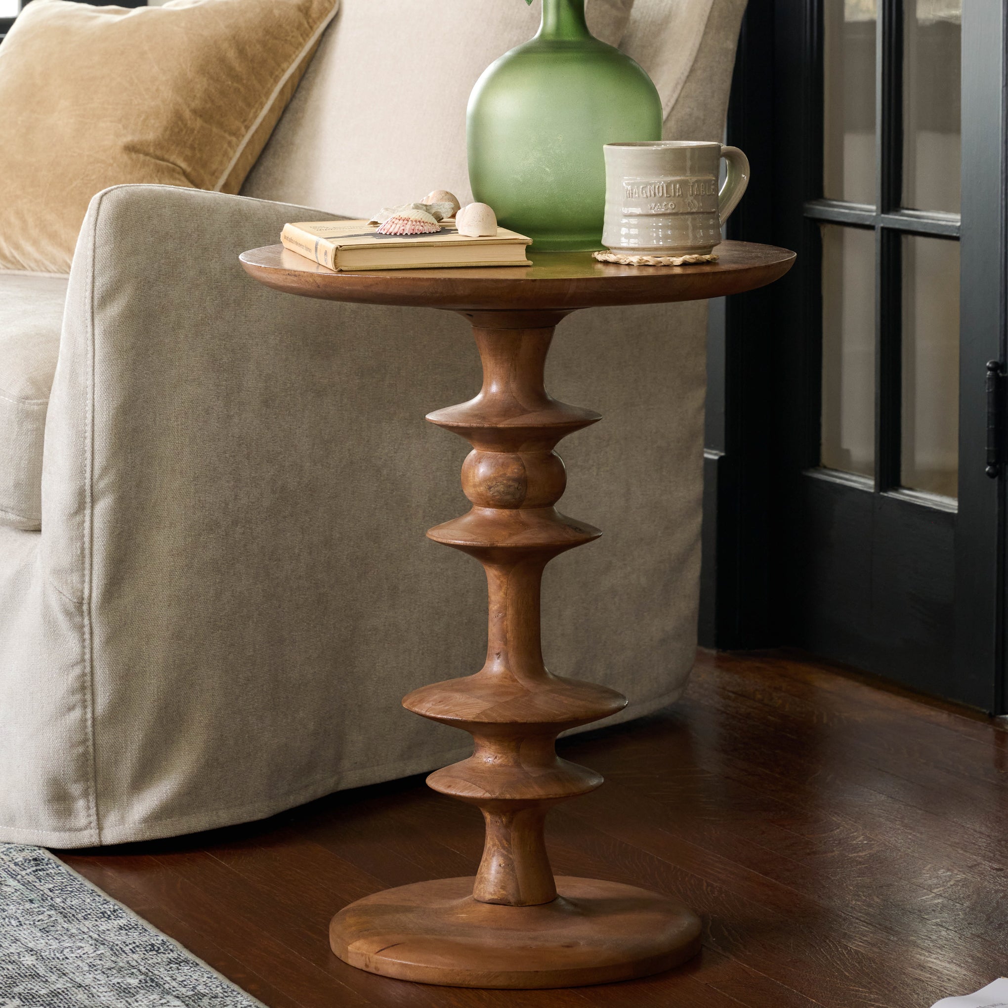 Enzo Turned Wood Side Table next to a sofa $218.00