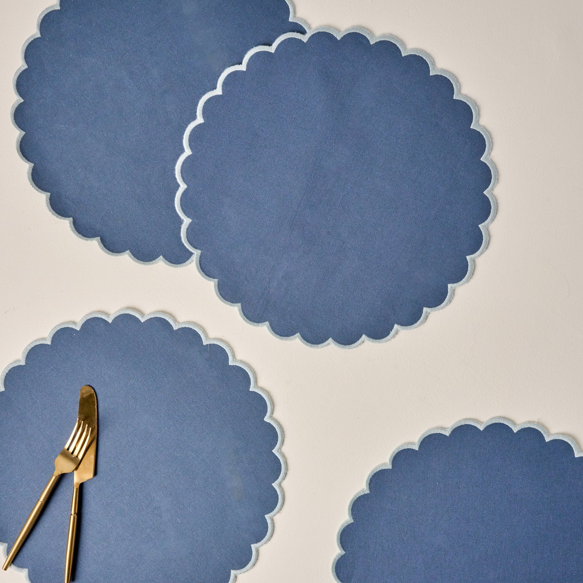 Orian Blue Scalloped Placemat Set of Four shown with utensils $32.00