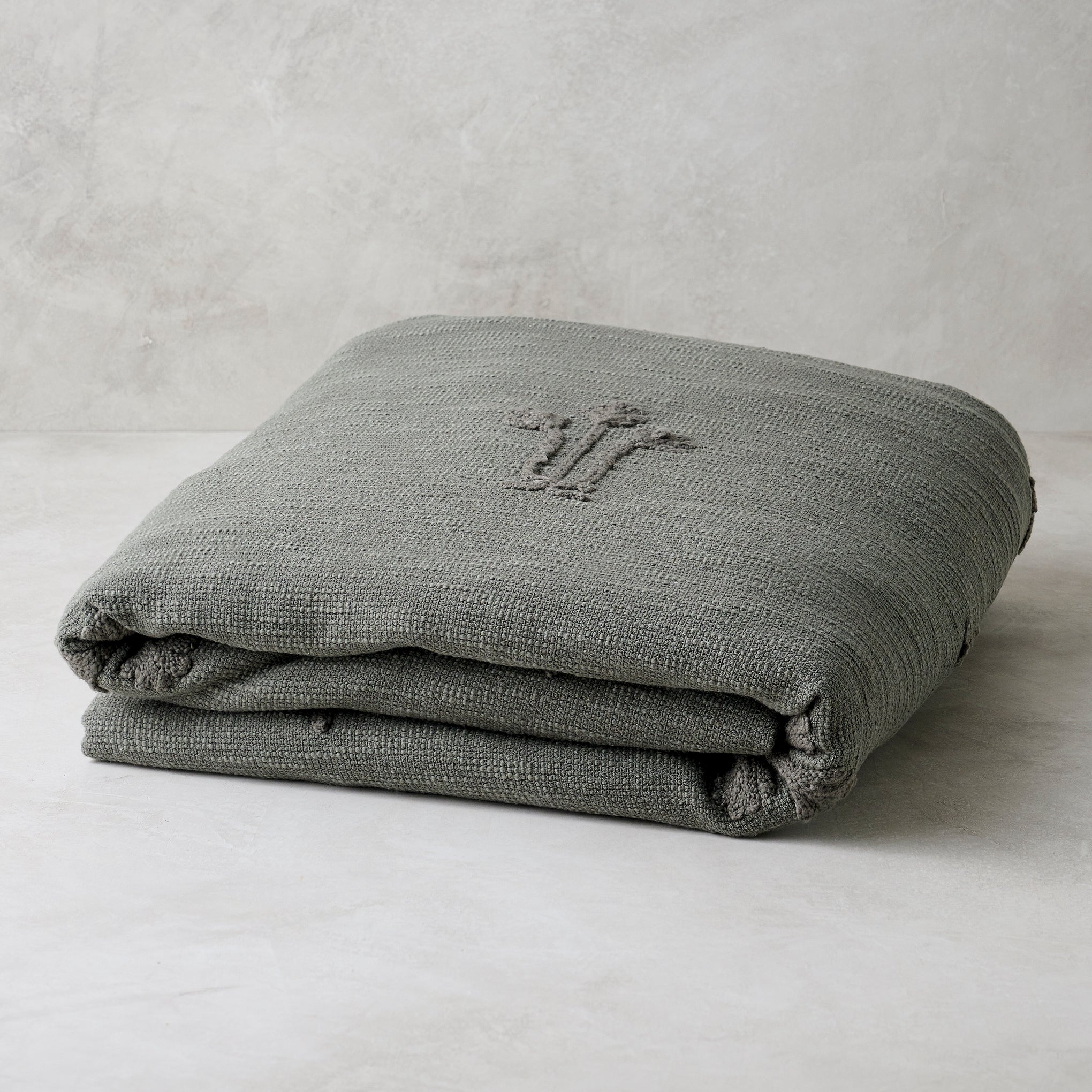 Petrol Blue Tulip Textured Coverlet shown folded On sale with items ranging from $149.99 to $169.99, discounted from $180.00 to $200.00