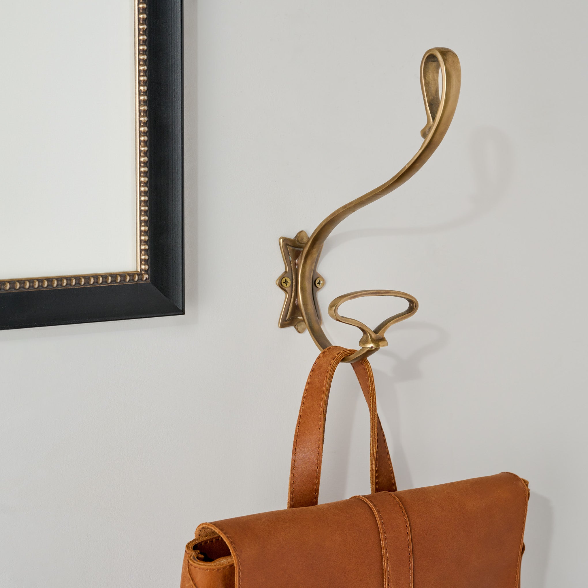 Jasper Antique Brass Wall Hook shown holding bag $28.00