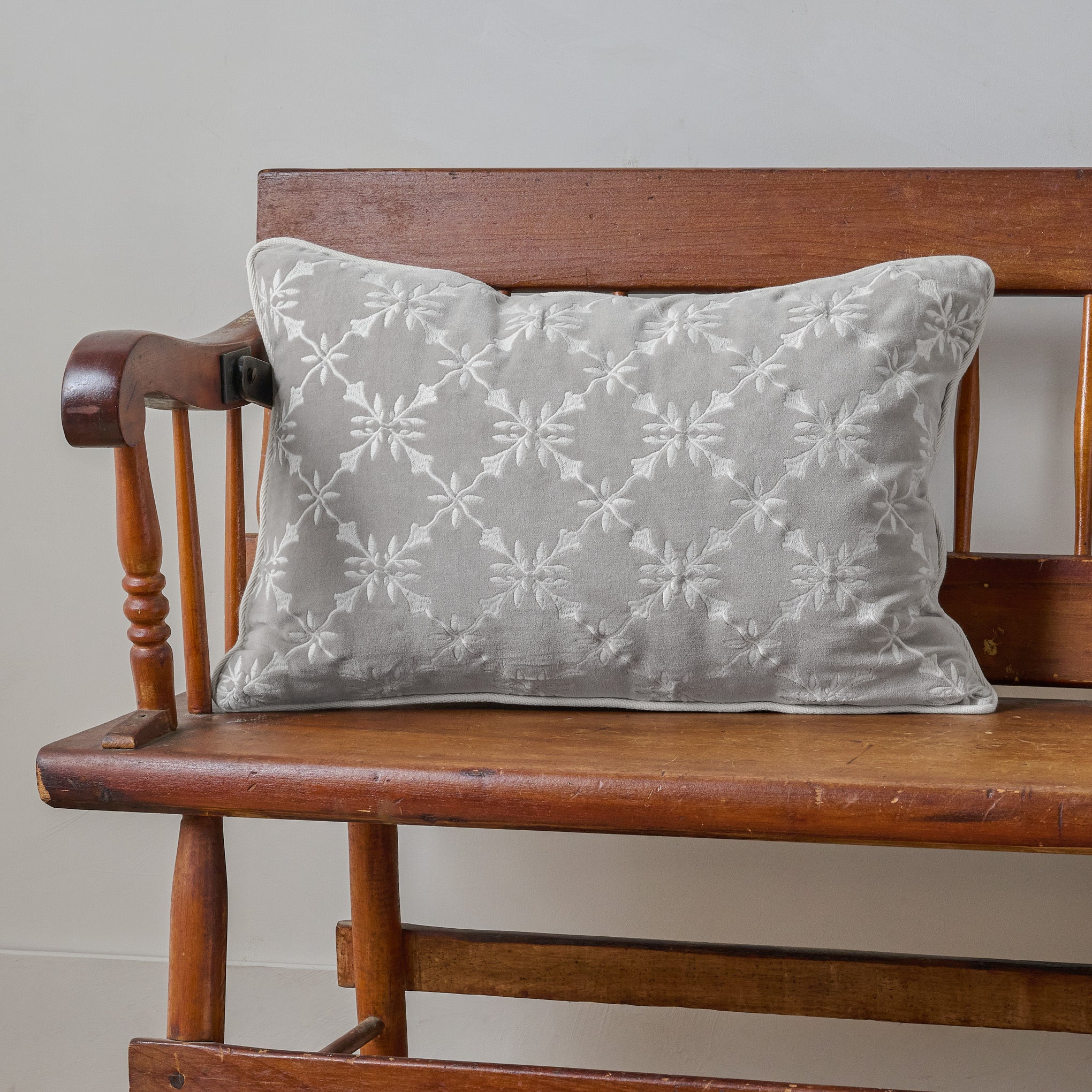 Aurora Embroidered Velvet Lumbar Pillow shown on bench $68.00