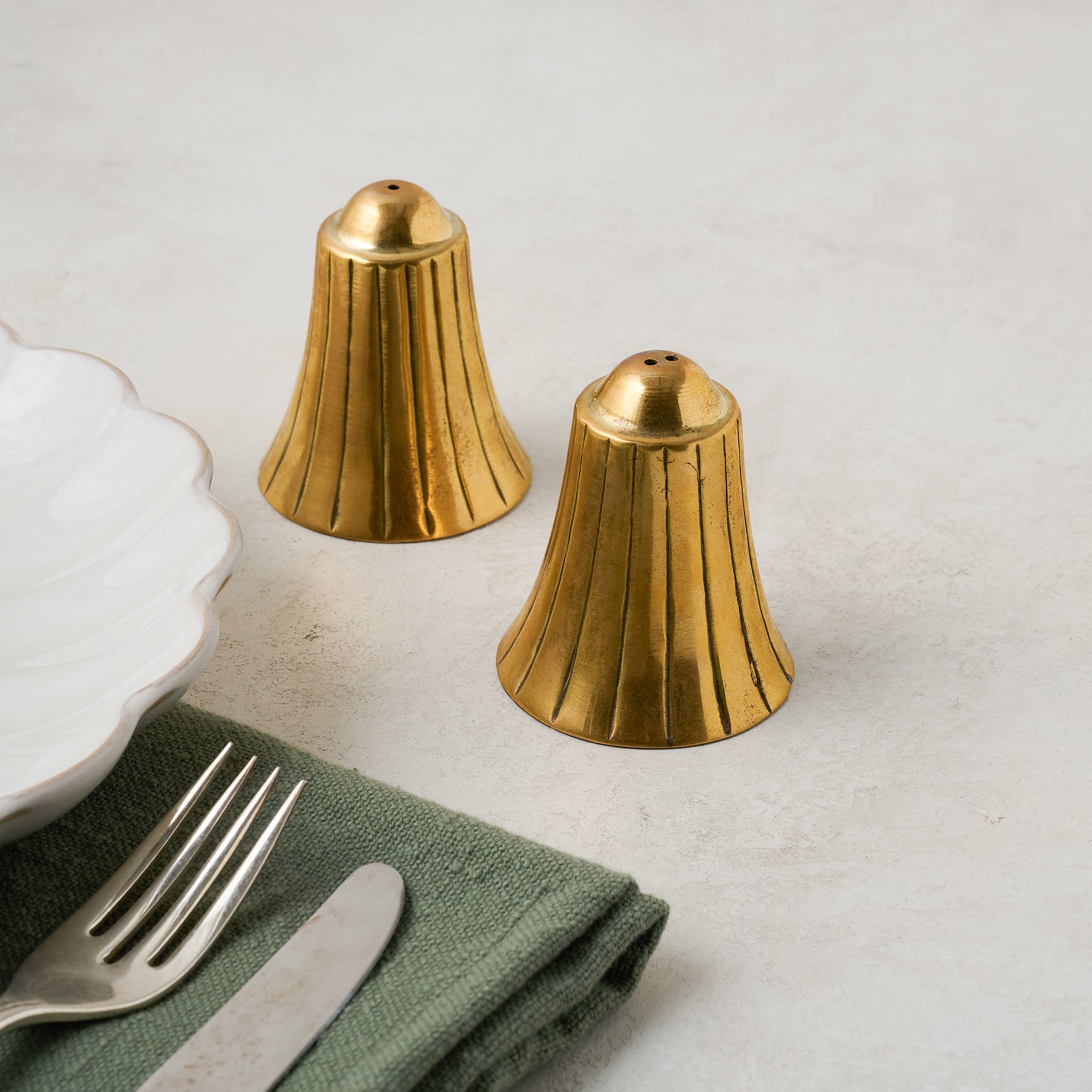 Brass Bell Salt + Pepper Set shown with place setting On sale for $19.99, discounted from $28.00