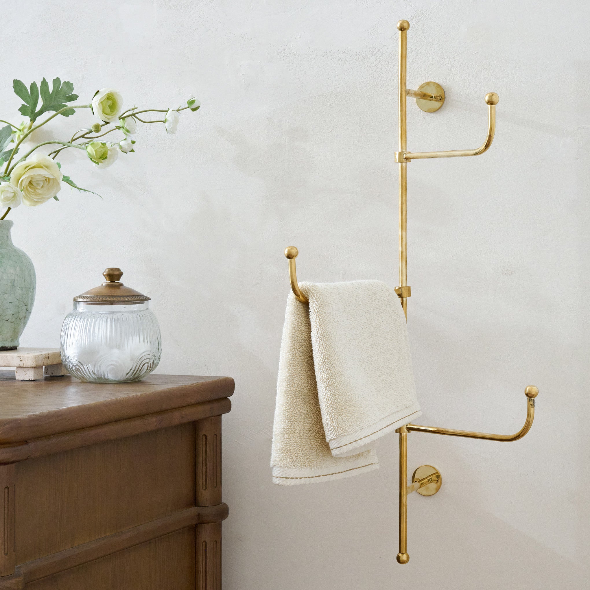 Jules Brass Vertical Towel Bar shown on wall in bathroom $98.00