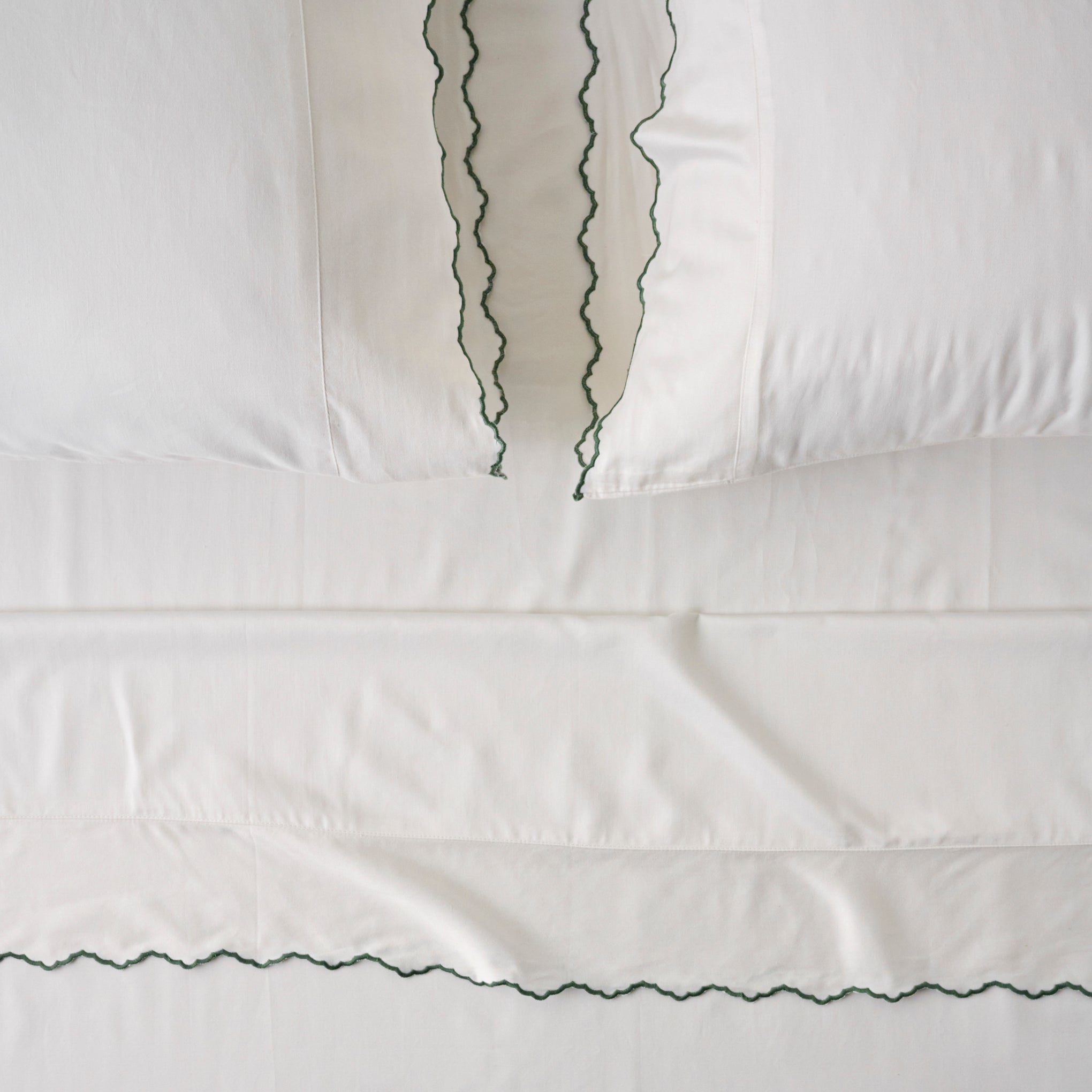 Optic White + Green Stitch Scalloped Edge Sheet Set Items range from $130.00 to $150.00