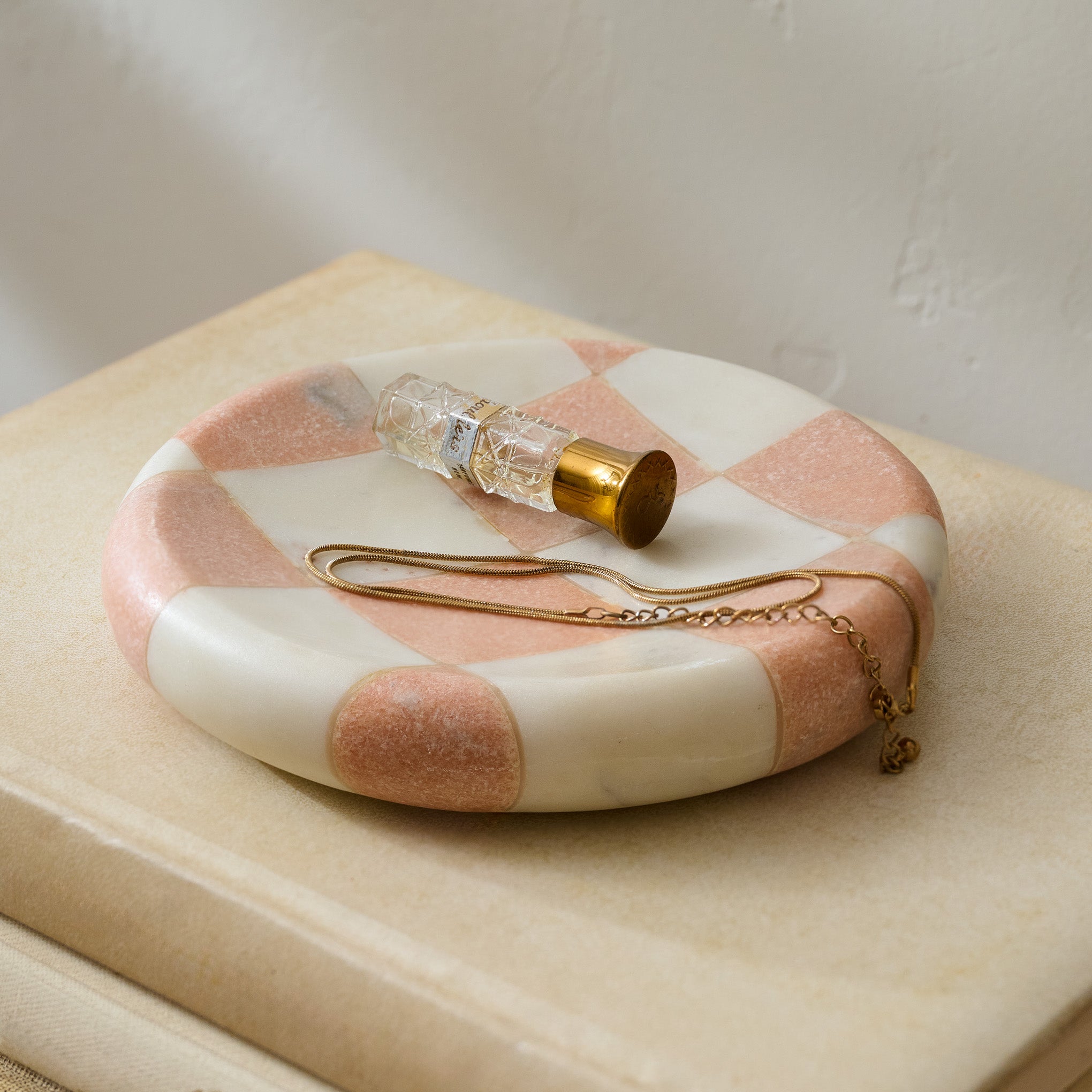 Carmella Checkered Marble Trinket Tray shown with perfume and jewelry $28.00