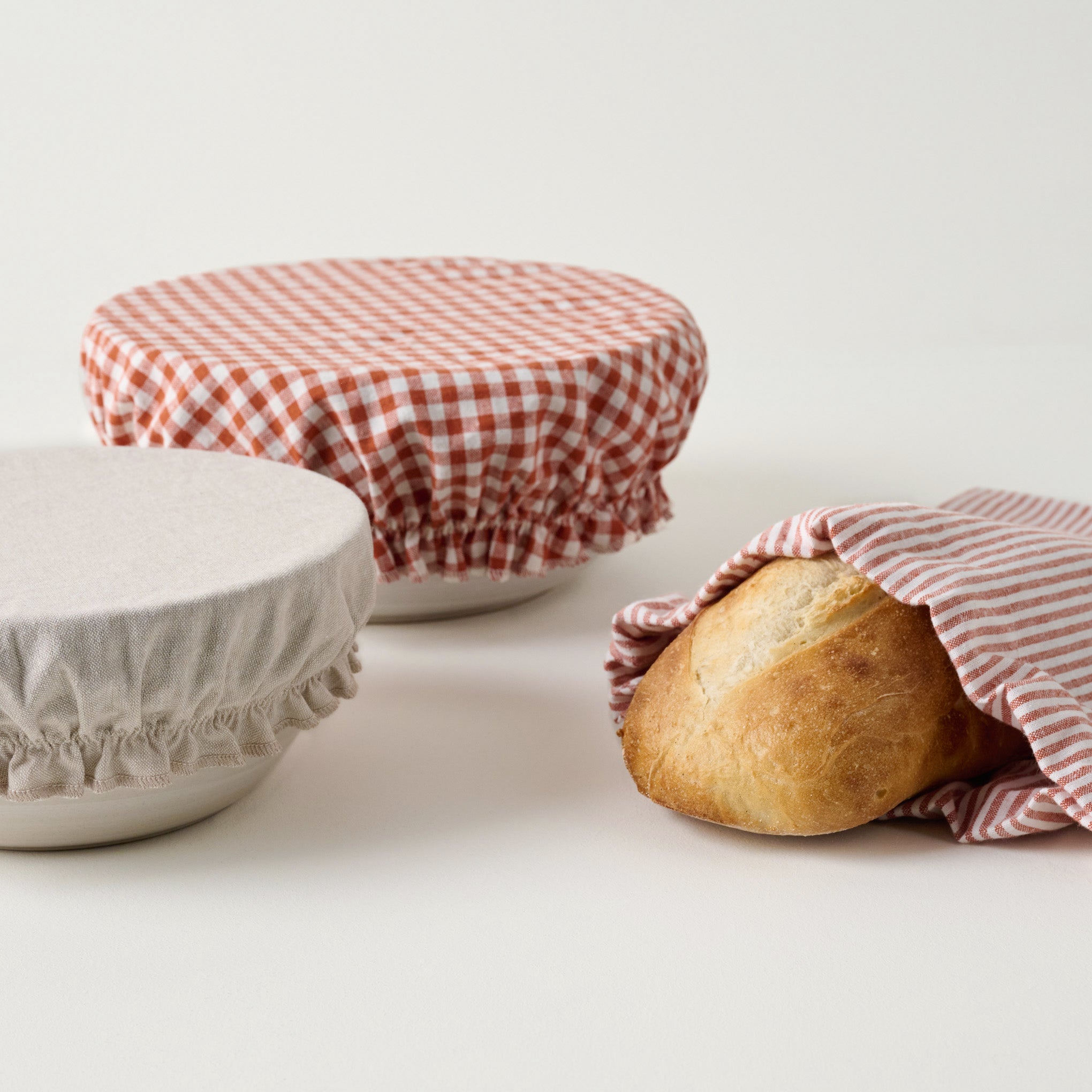 Orange Gingham Bread Bowl Cover & Bag Set shown with bread